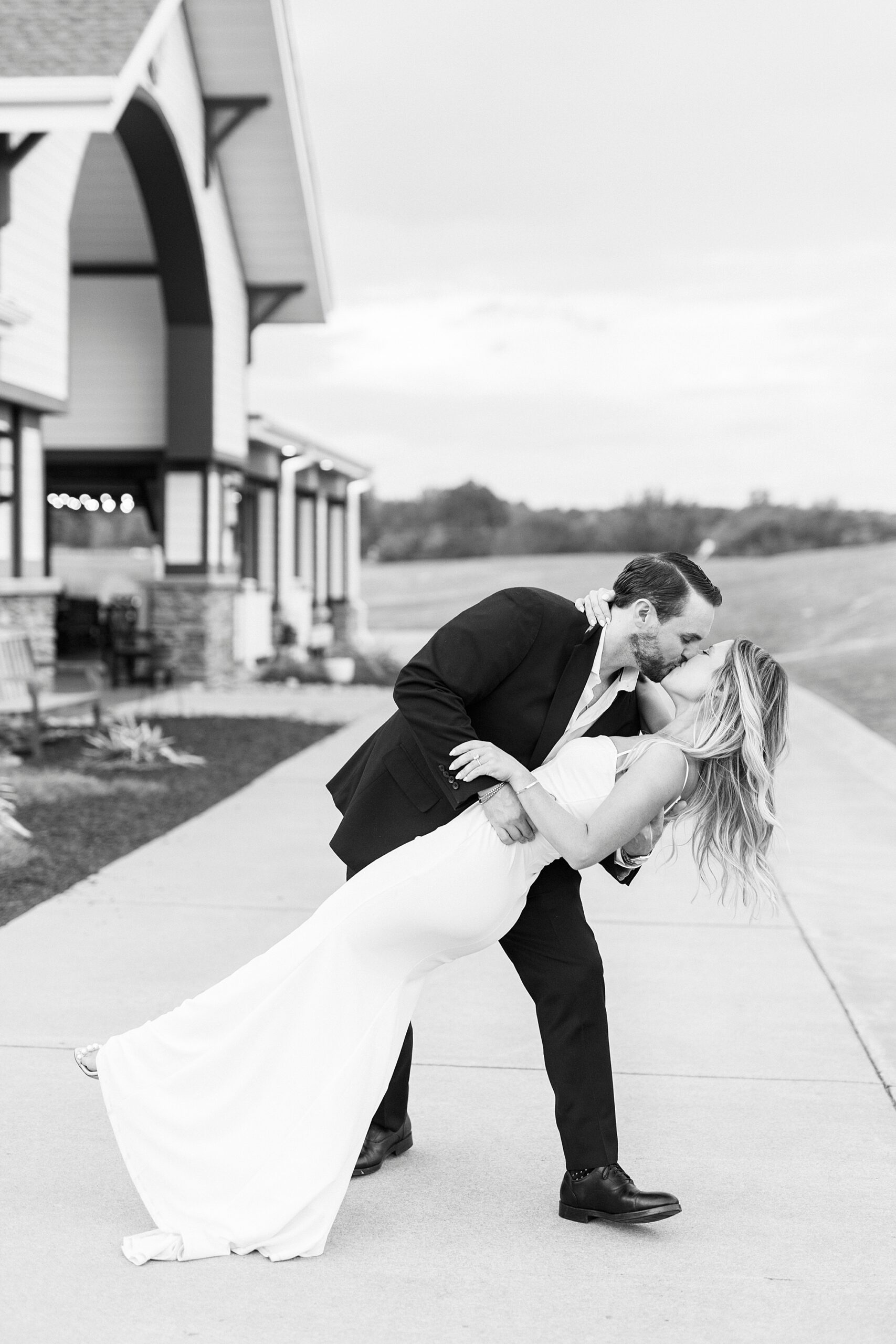 groom dips bride kissing her outside the Venues at Langtree
