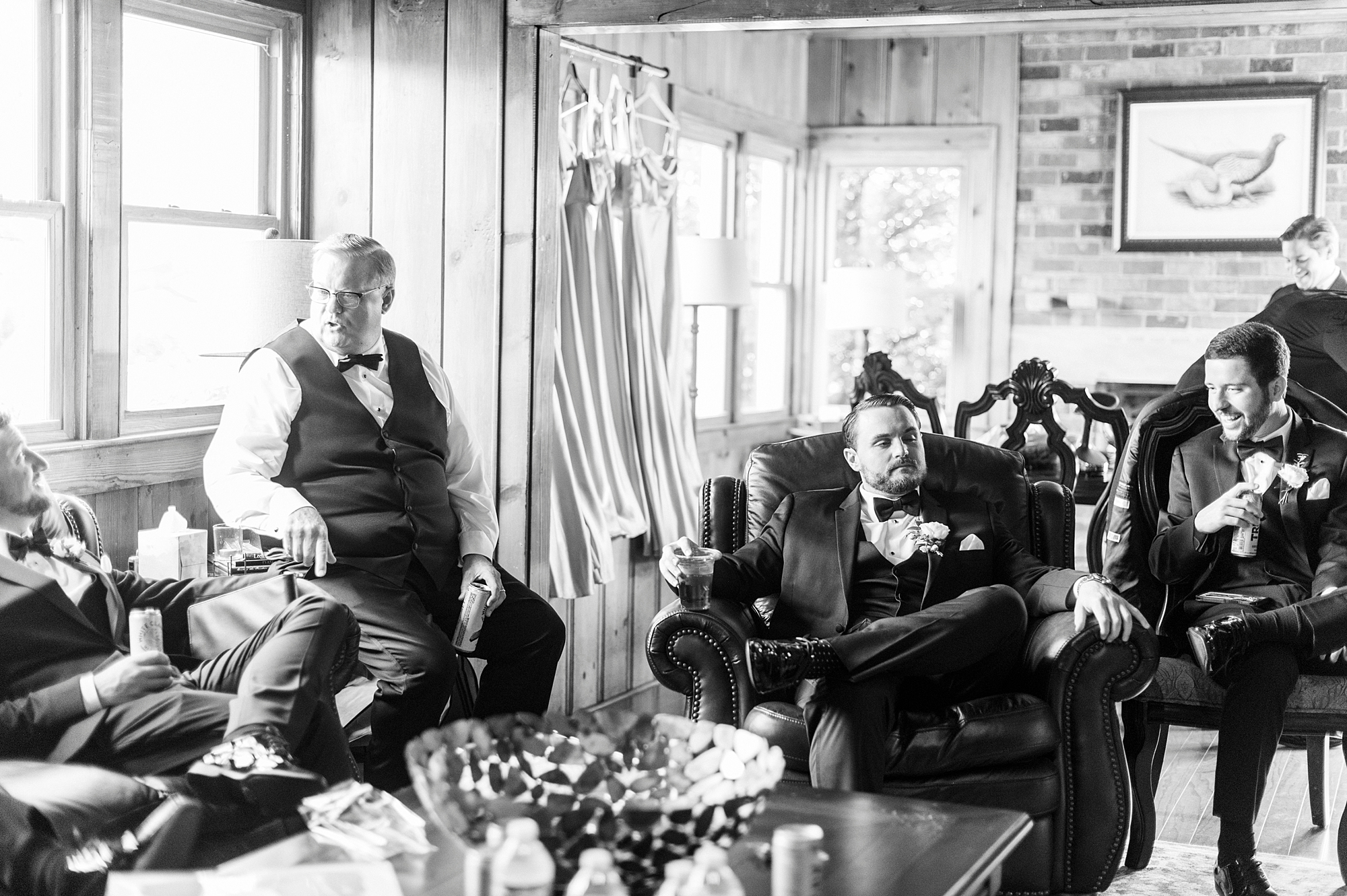 groom and groomsmen sit around suite at the Venues at Langtree