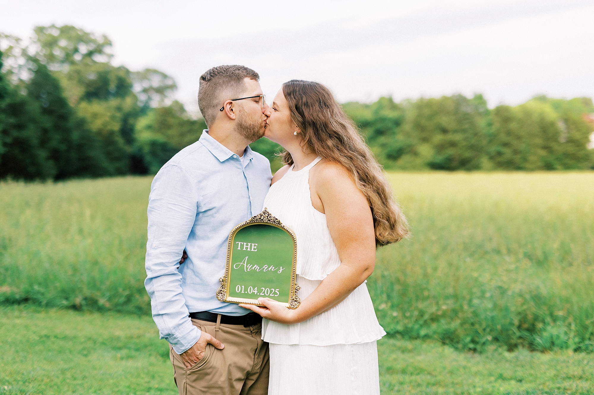 engaged couple holds mirror with date of wedding