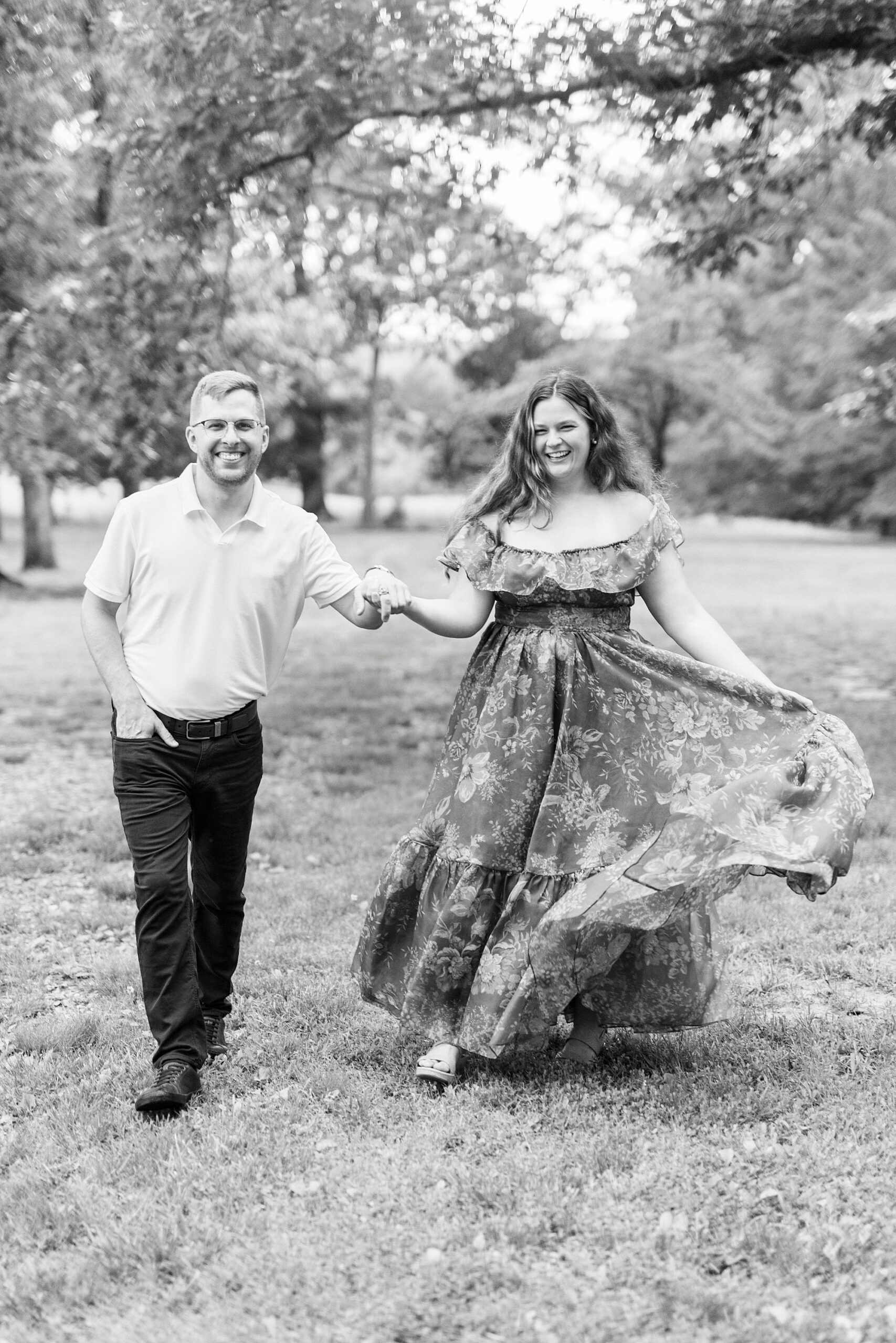 woman holds side of skirt out twirling it walking with man