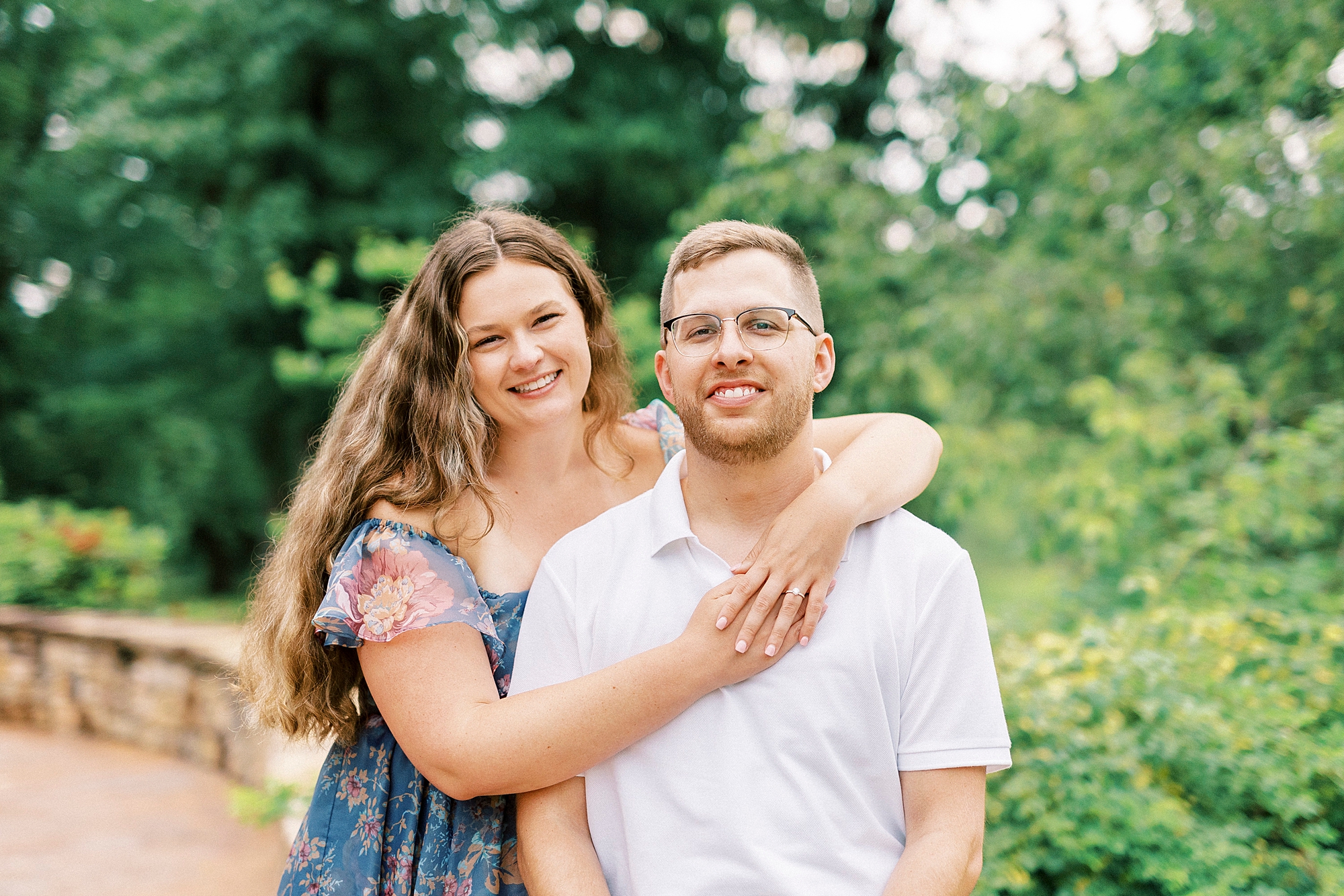 woman hugs man from behind wrapping her arms around his neck