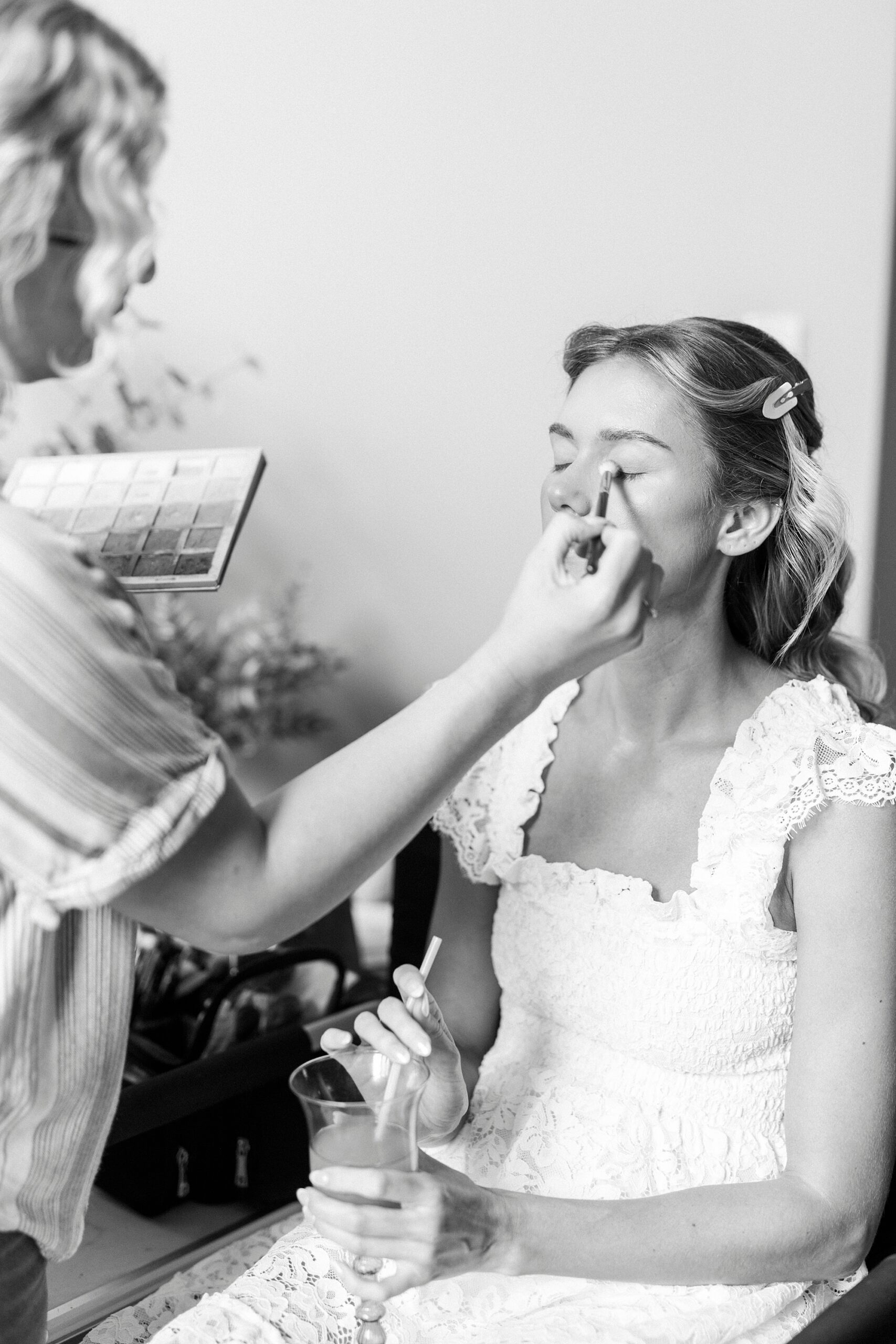 makeup artist applies eye shadow for bride during spring wedding day prep