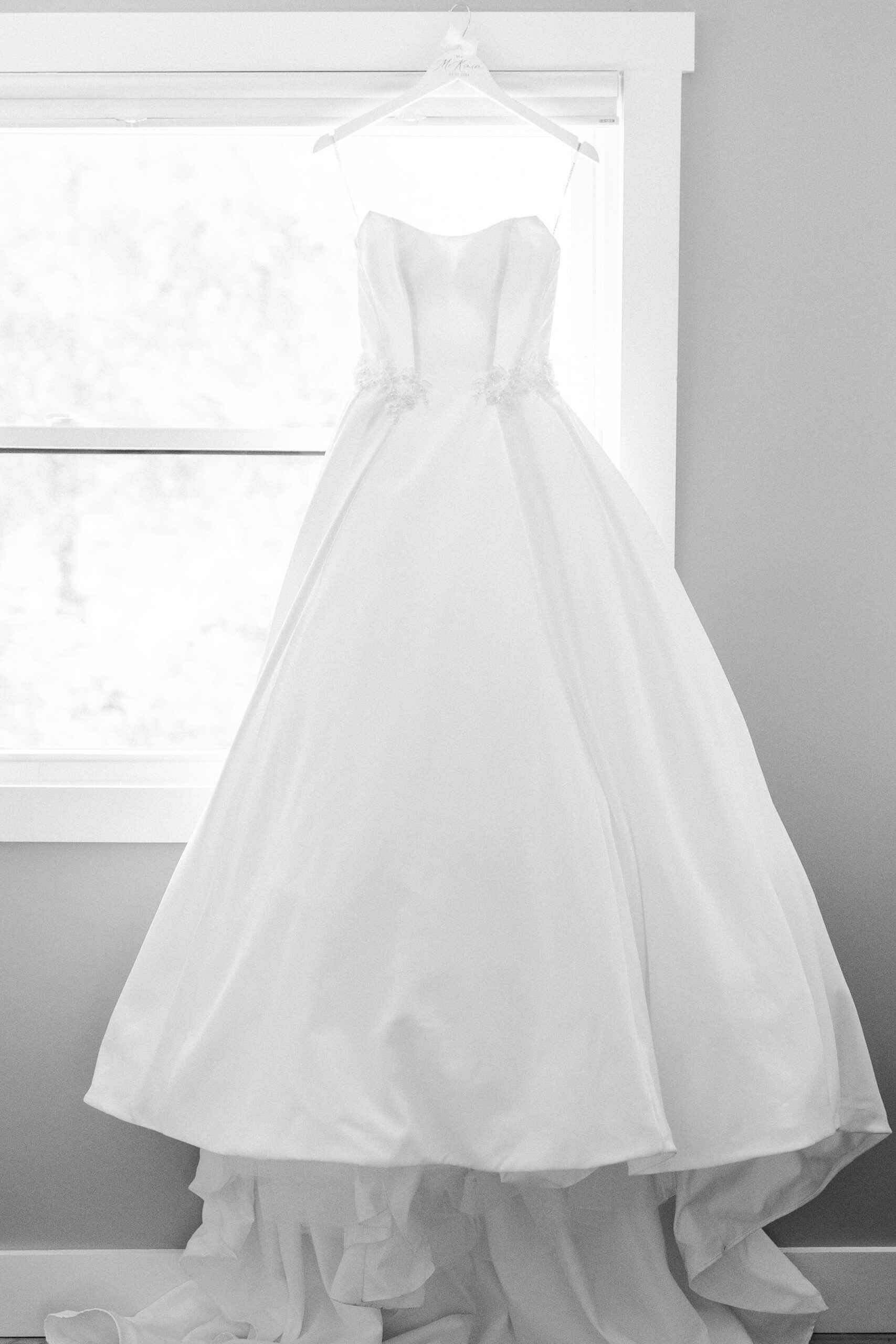 wedding dress hangs in window of suite at Separk Mansion