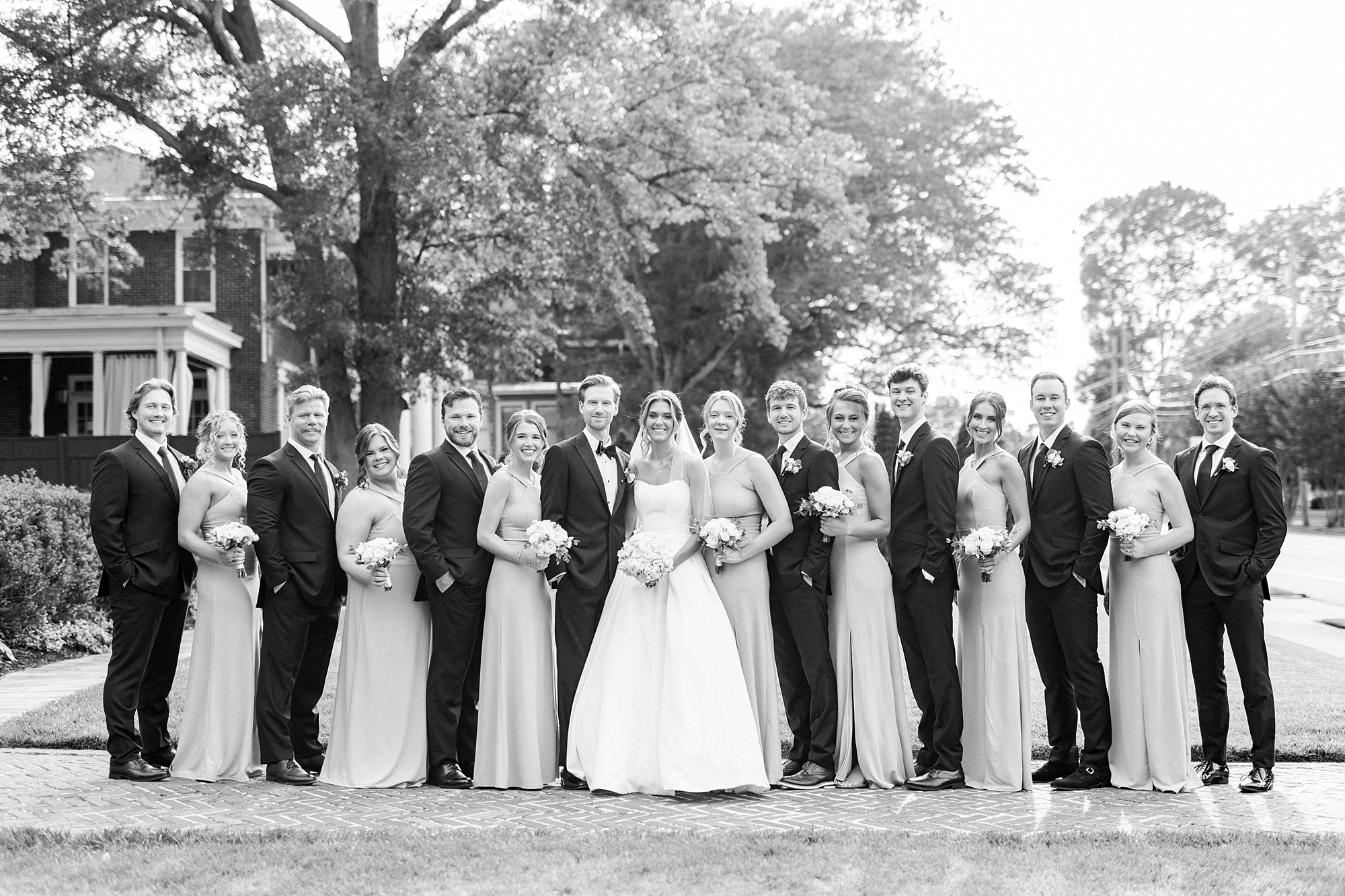 bride and groom stand with wedding party in garden of Separk Mansion