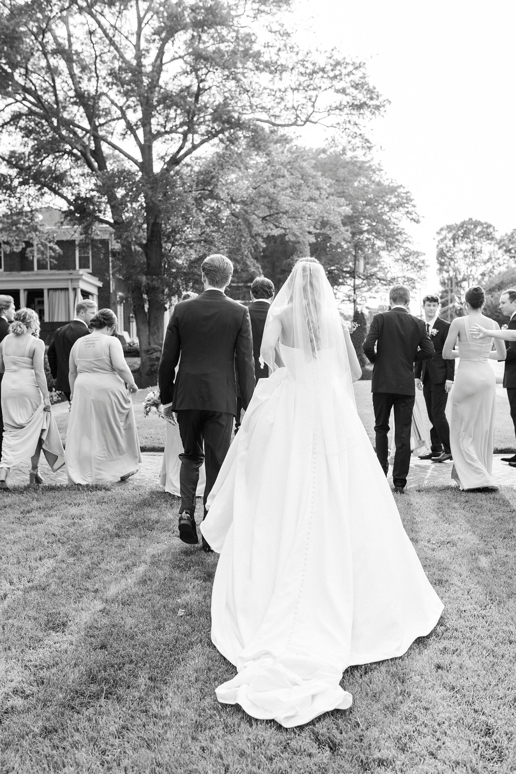 bride and groom walk away from camera holding hands