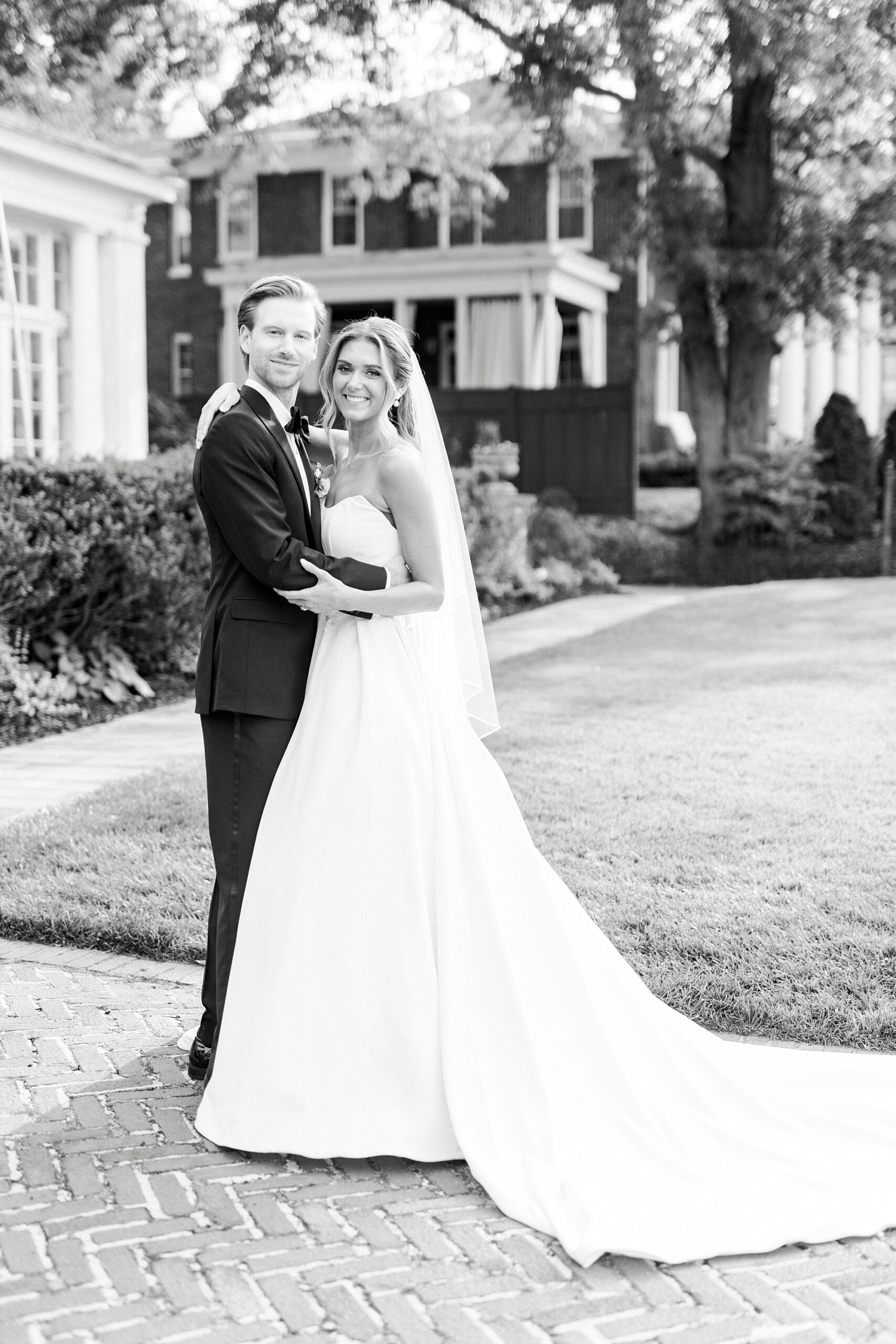 newlyweds hug each other around the waist on lawn at Separk Mansion