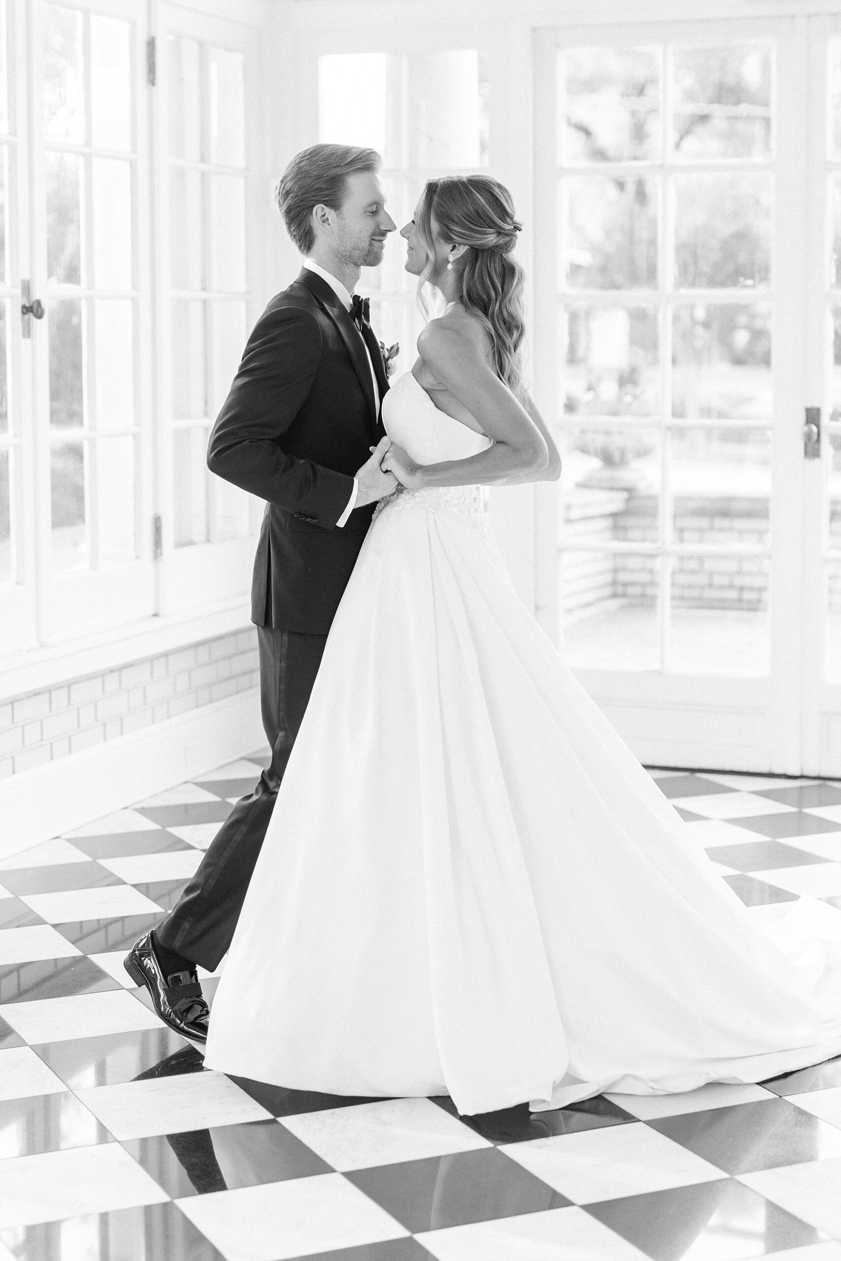 newlyweds hold hands dancing in sunroom of Separk Mansion