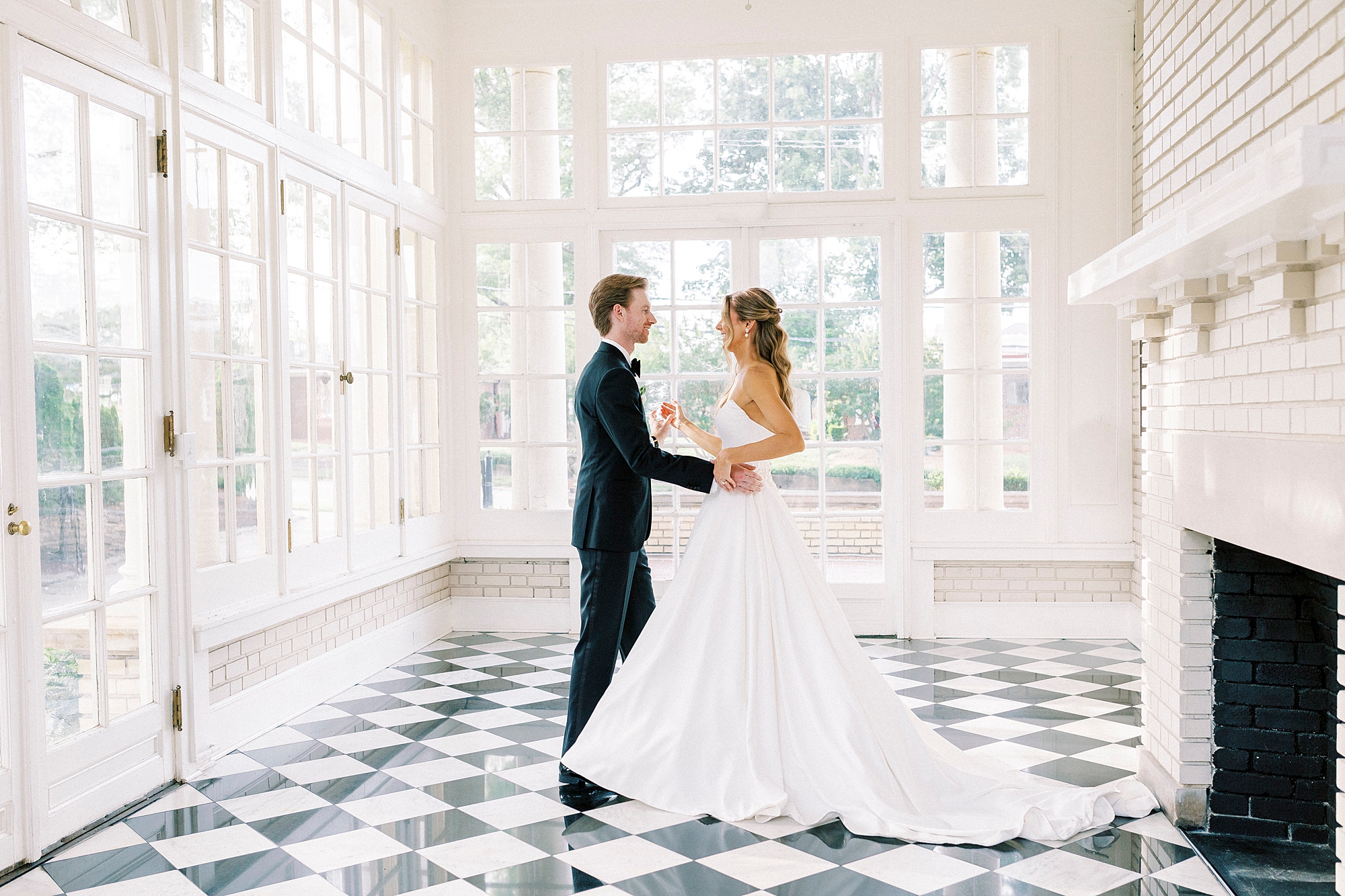 bride and groom dance on black and white floor of sunroom