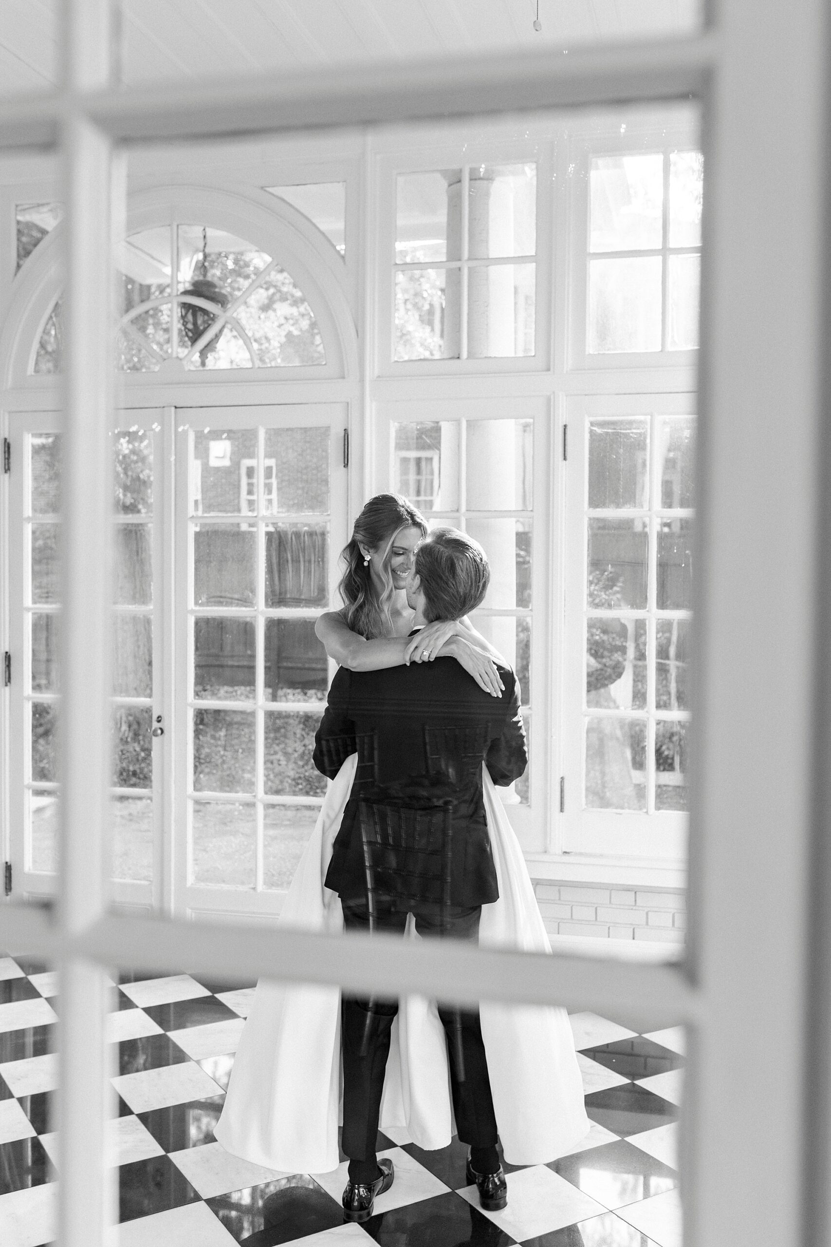 groom lifts up bride in sunroom of Separk Mansion