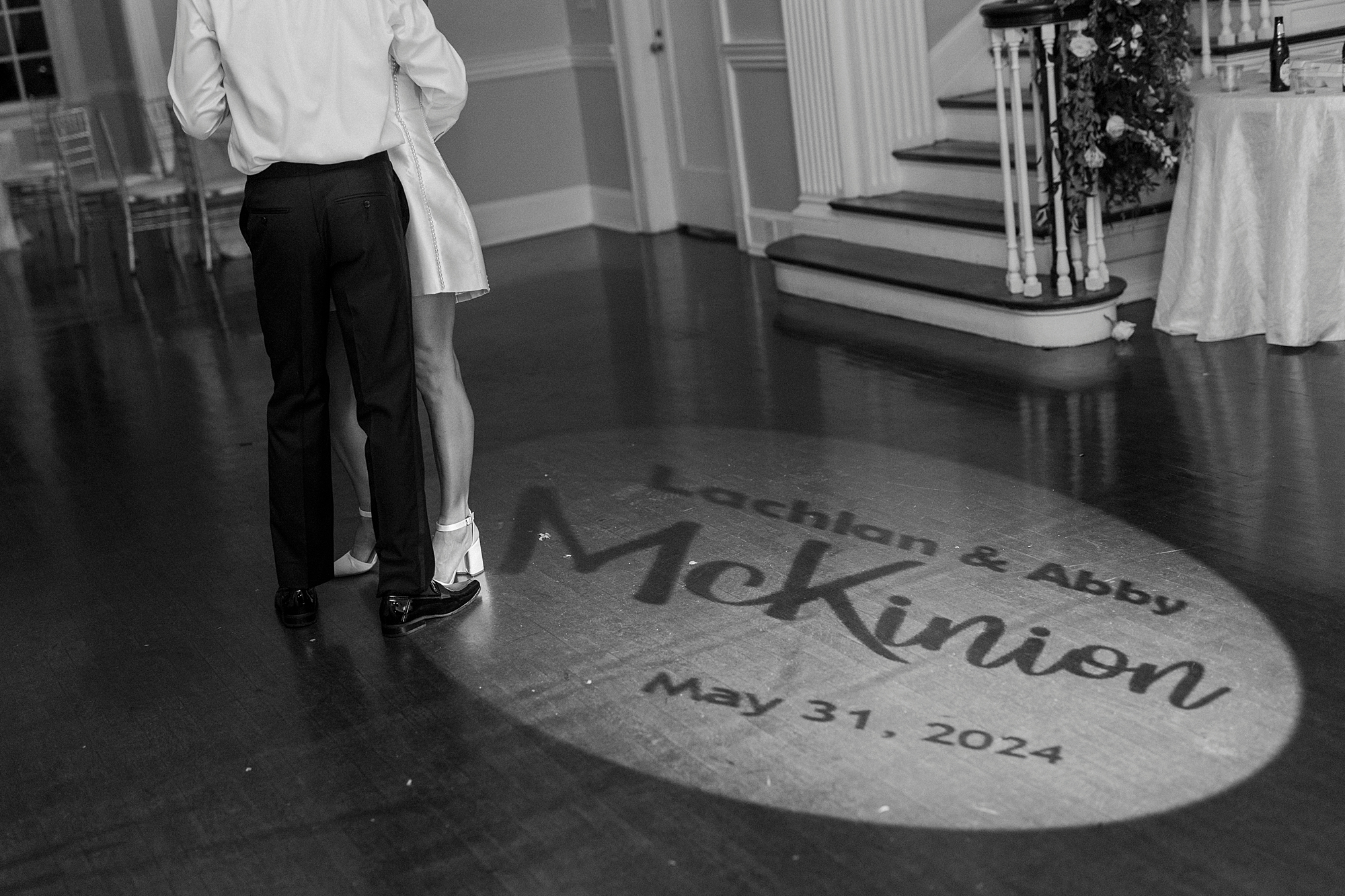 newlyweds dance with custom light display on floor next to them