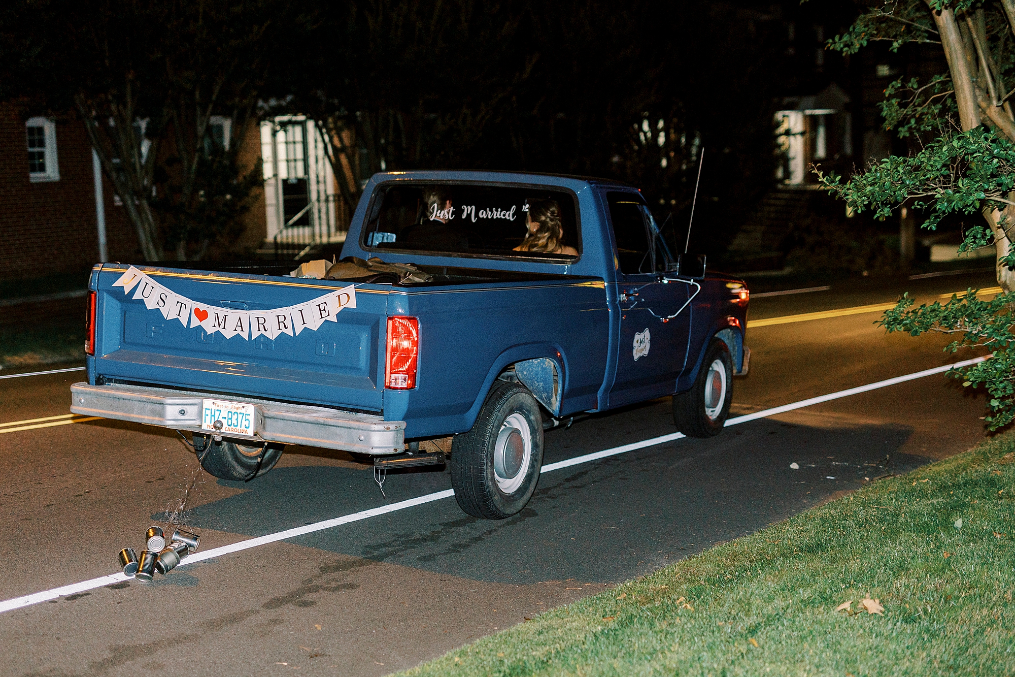 bride and groom drive off in classic blue truck