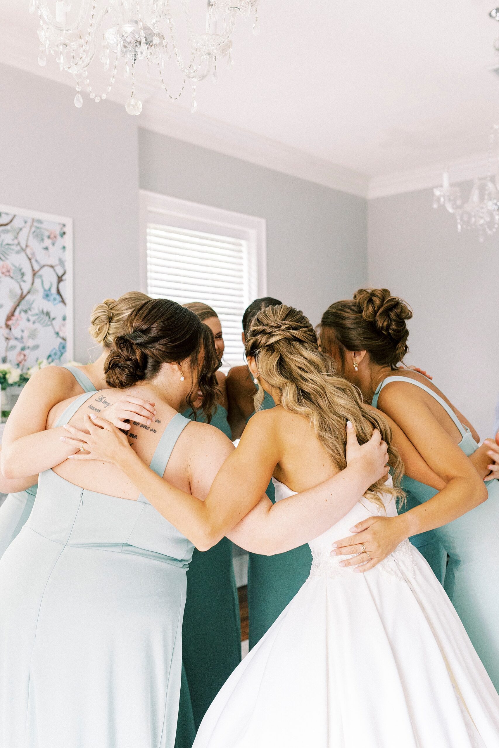 bridesmaids and mothers pray over bride during prep in suite at Separk Mansion