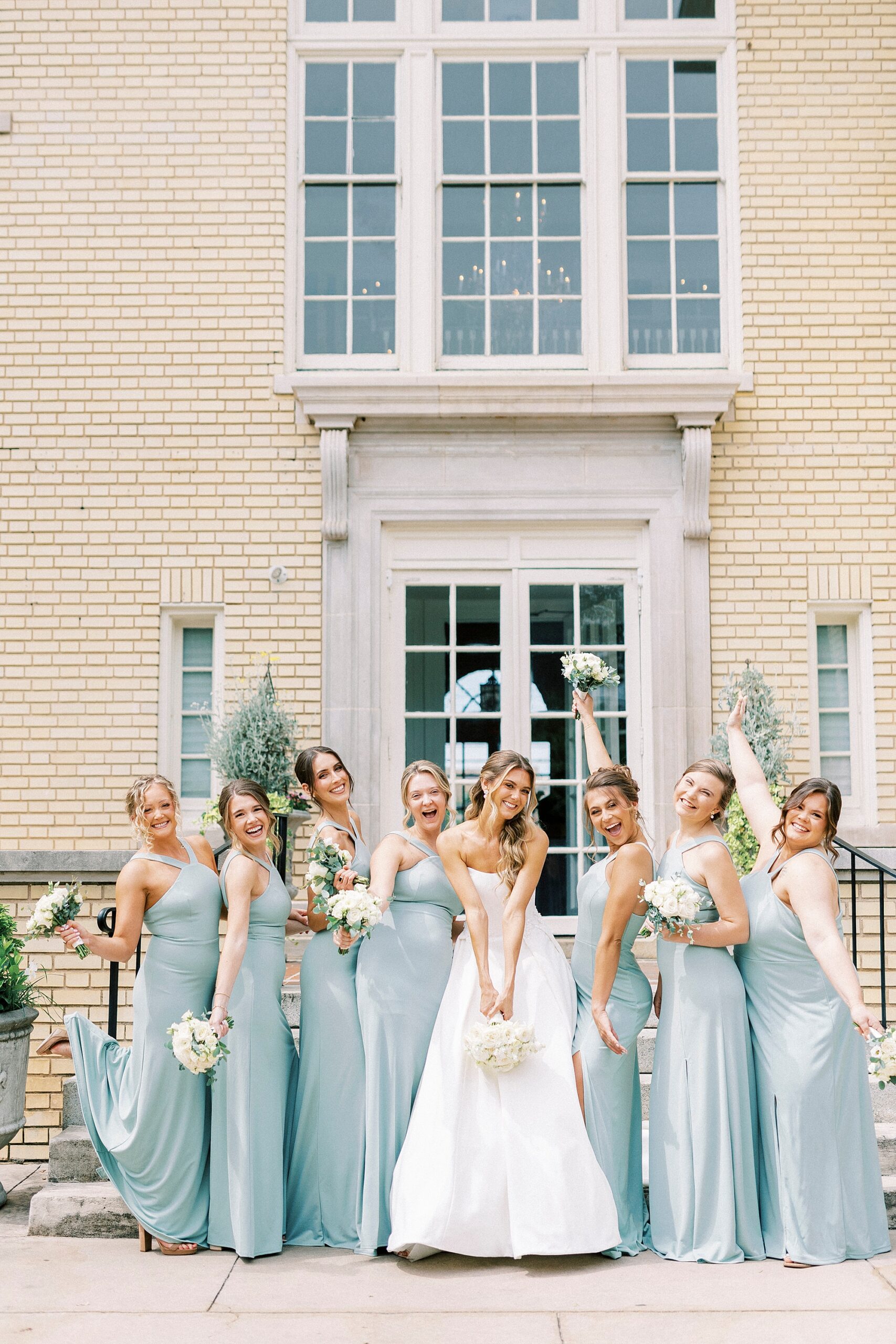 bride and bridesmaids in light blue gowns cheer outside Separk Mansion