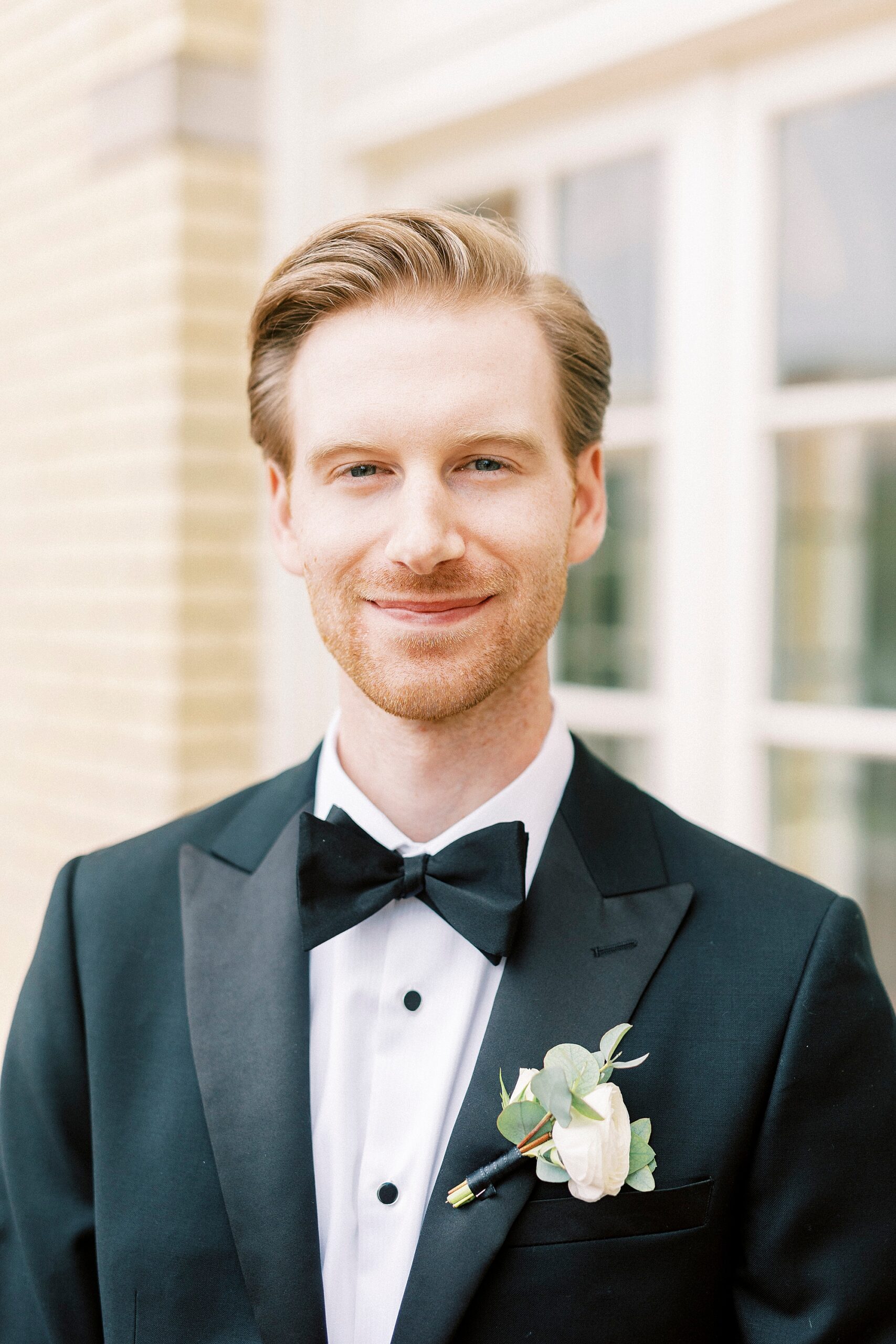 groom in black suit with white boutonnière for spring wedding