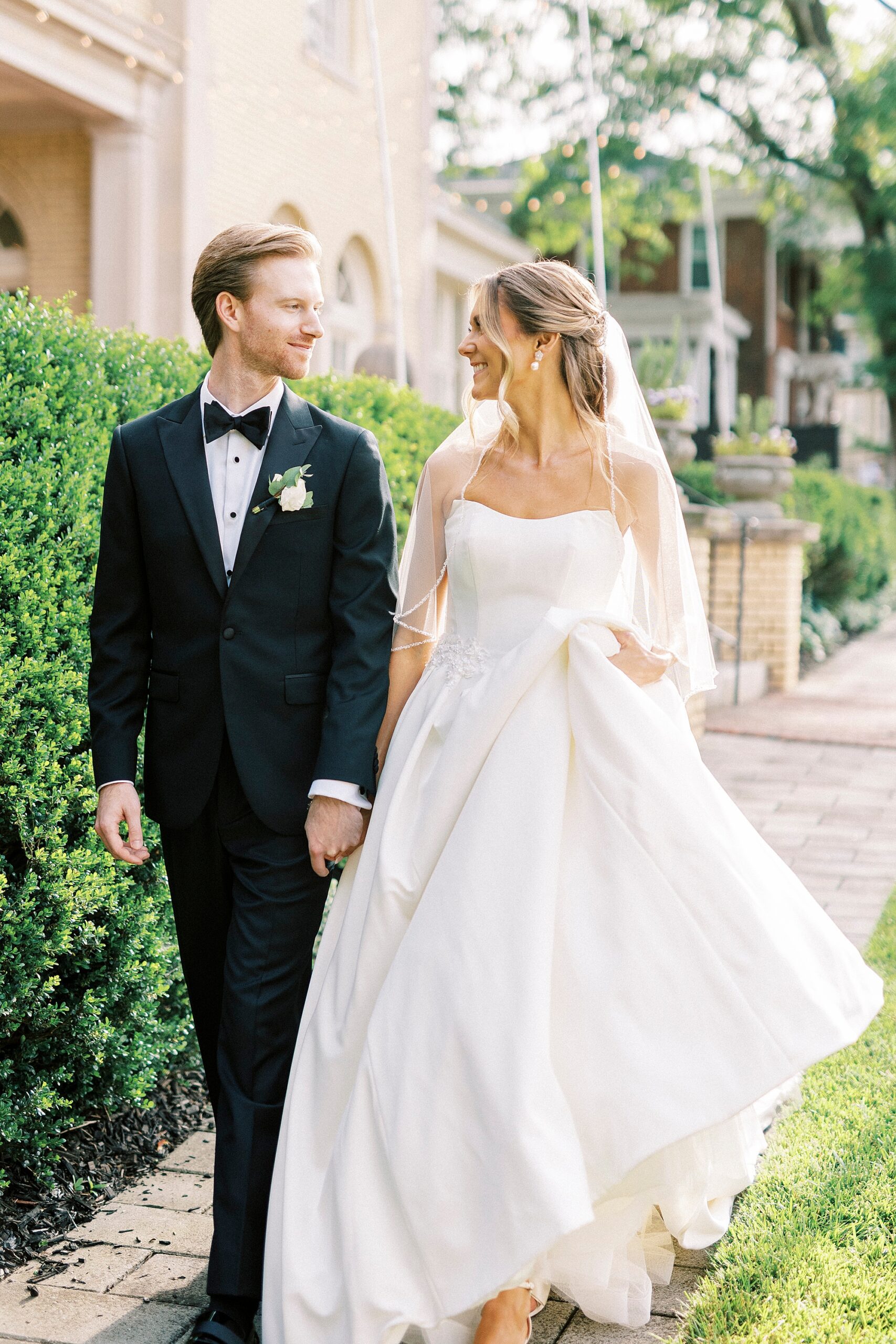 bride and groom hold hands smiling at each other walking through garden at Separk Mansion