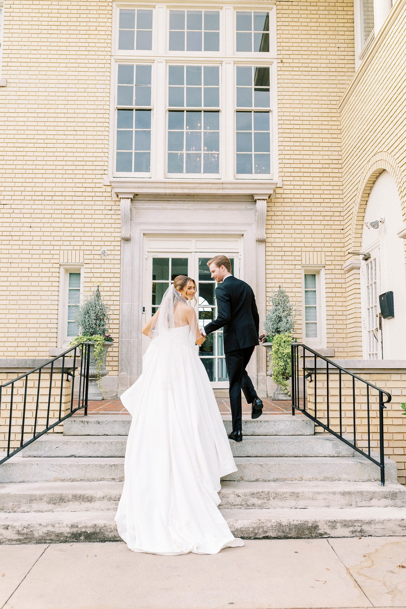bride and groom walk up staircase outside Separk Mansion