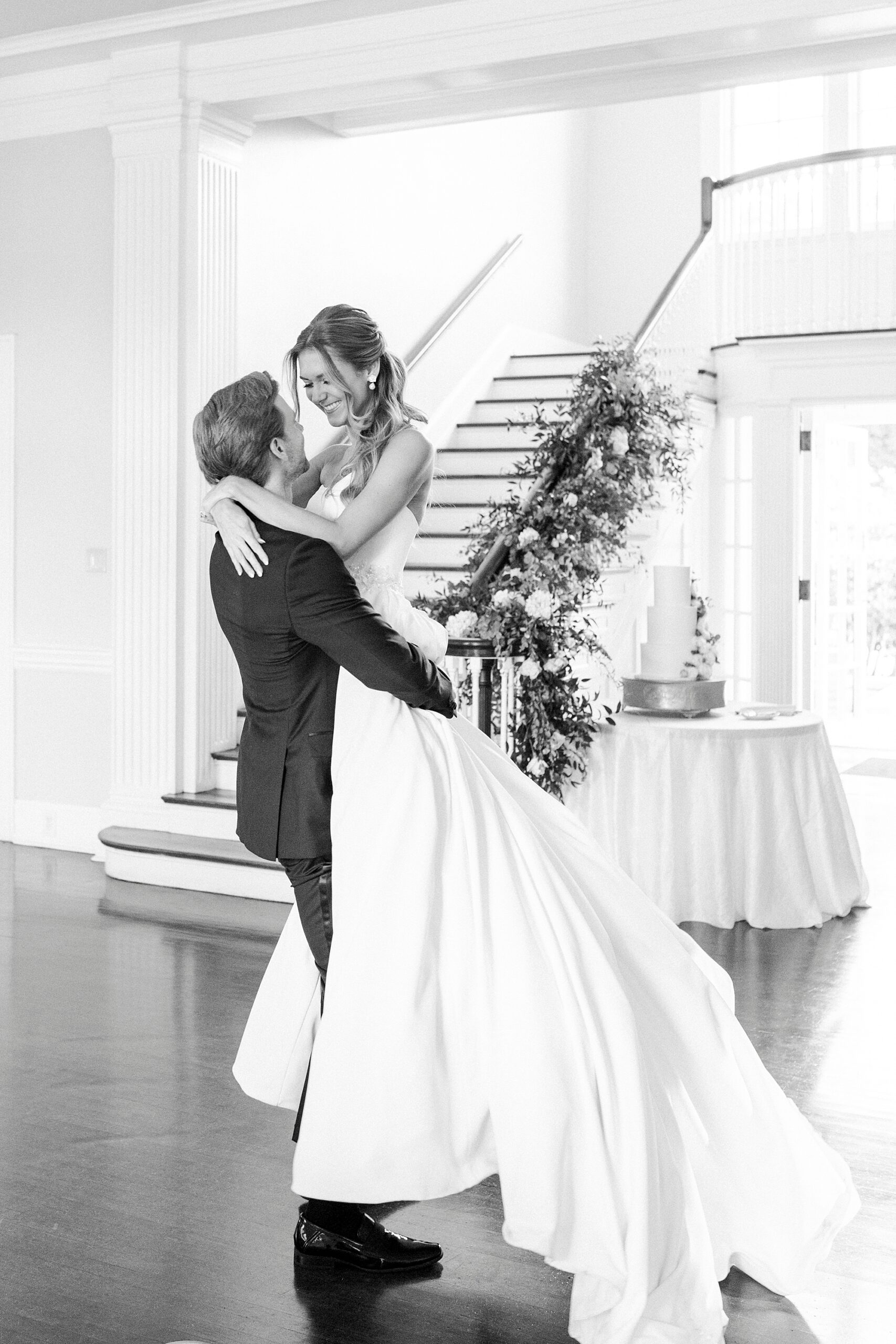 groom lifts up bride during reception near staircase at Separk Mansion