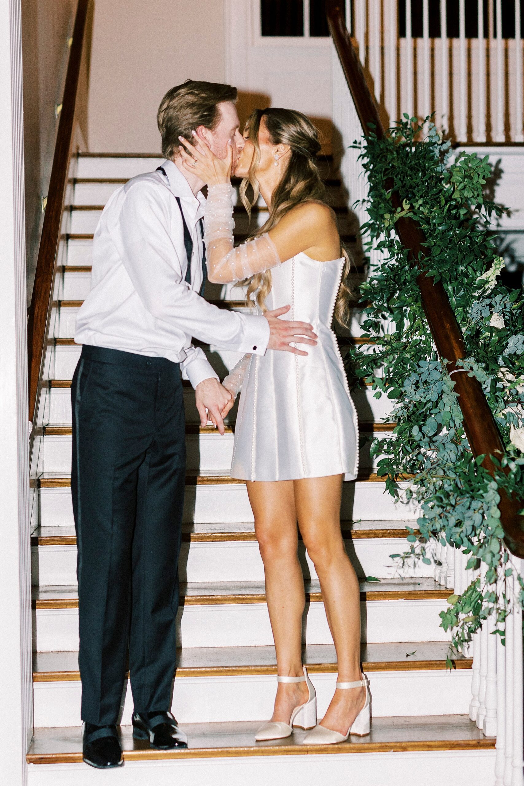 groom hugs bride in short white party dress