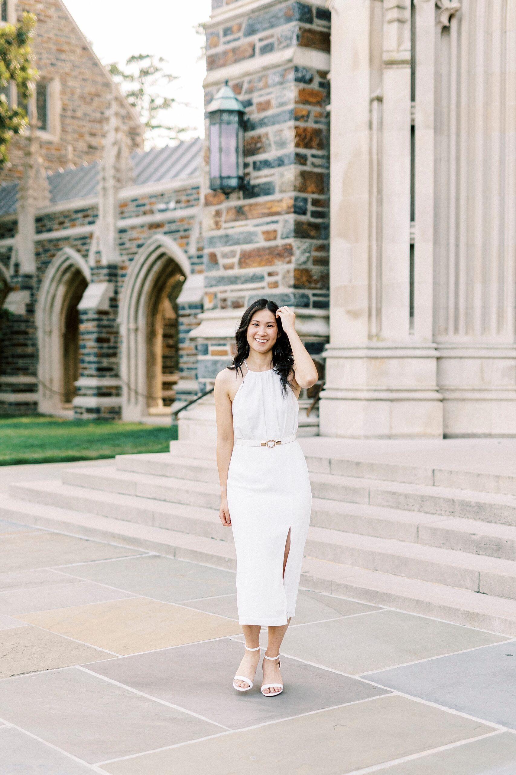 woman walks in front of chapel in white dress