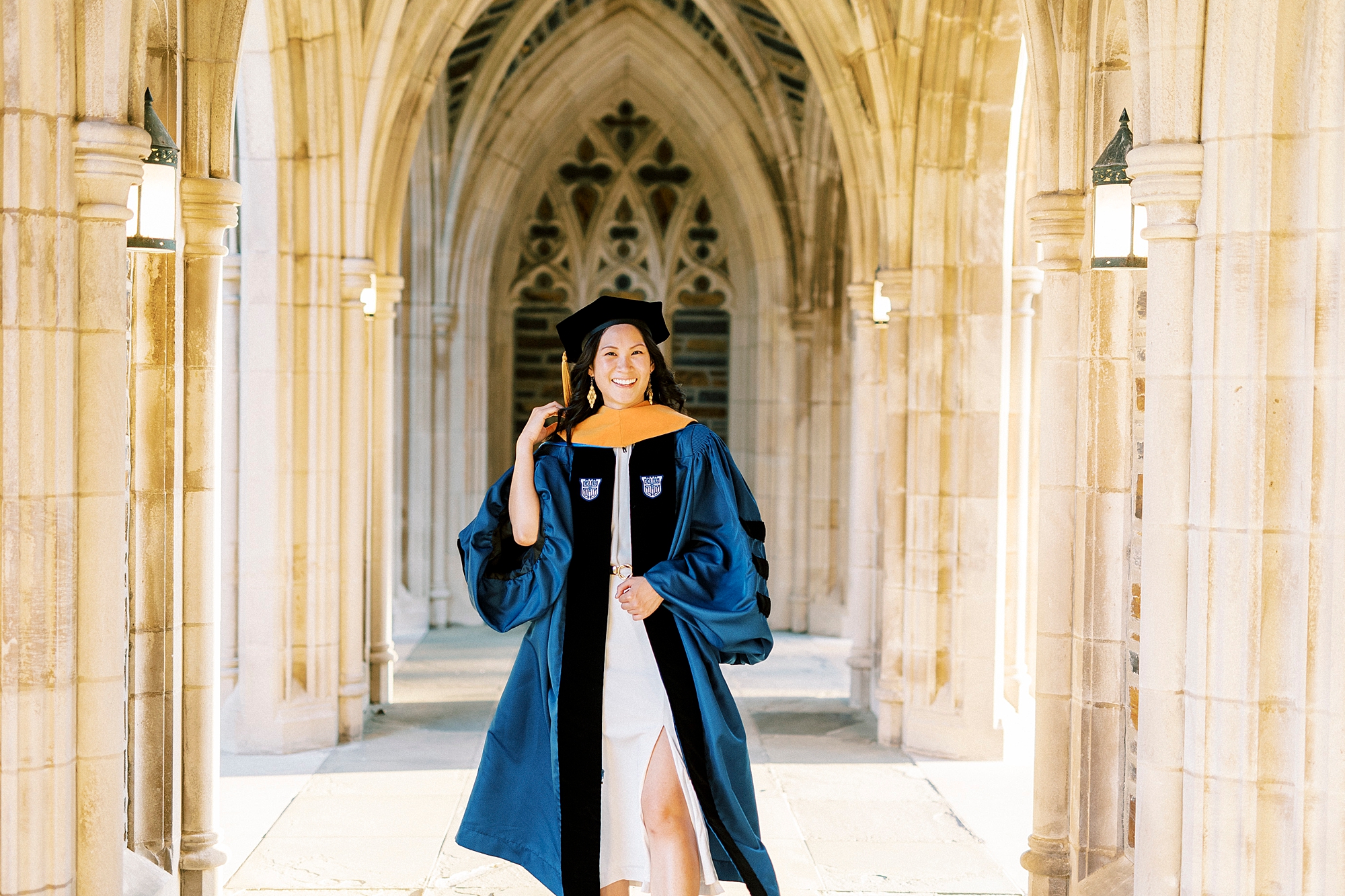 woman walks in hallway of Duke University chapel in graduation robe