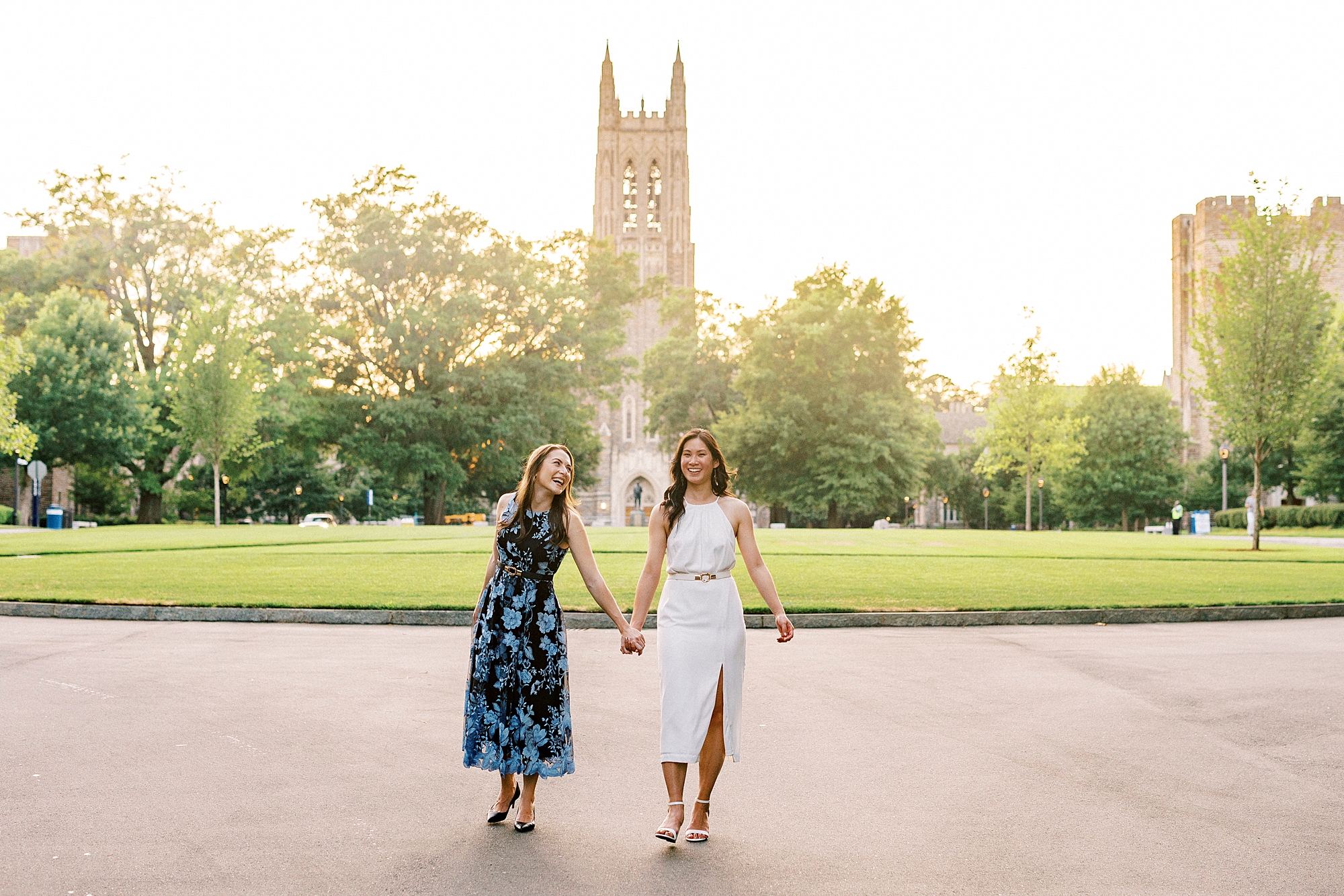 two friends hold hands walking on campus at Duke University