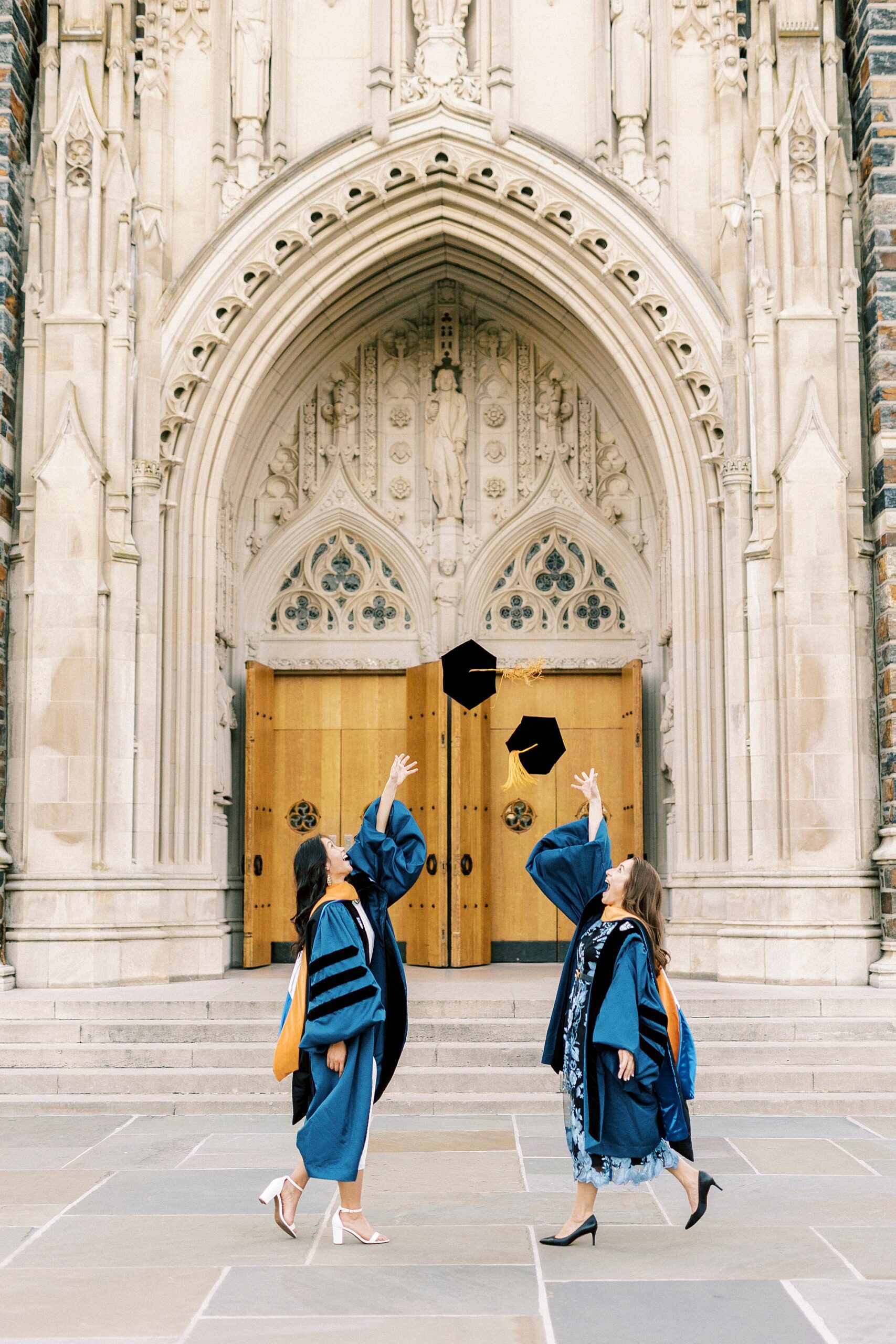 graduates toss hats during portraits for graduation