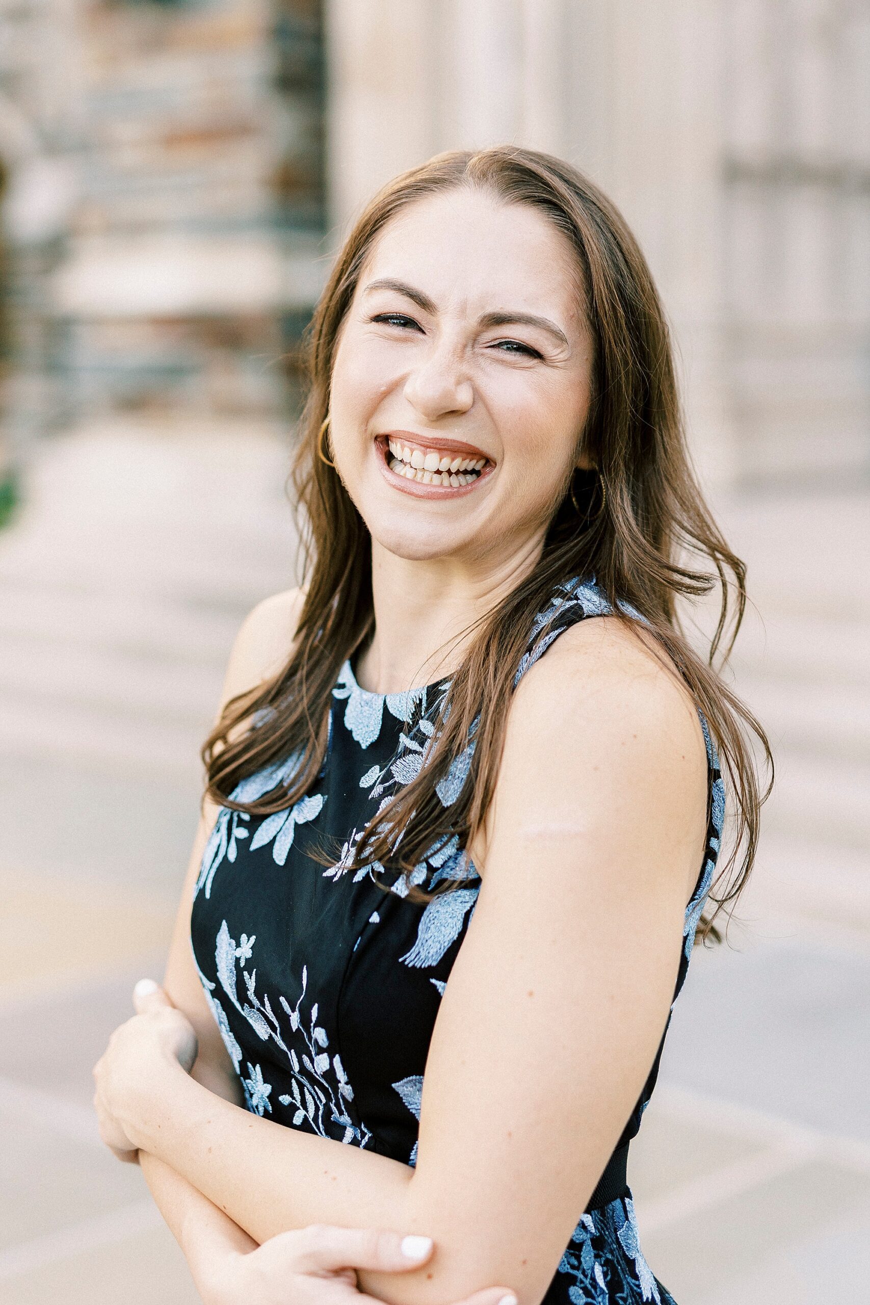 woman laughs during senior portraits on steps at Duke University