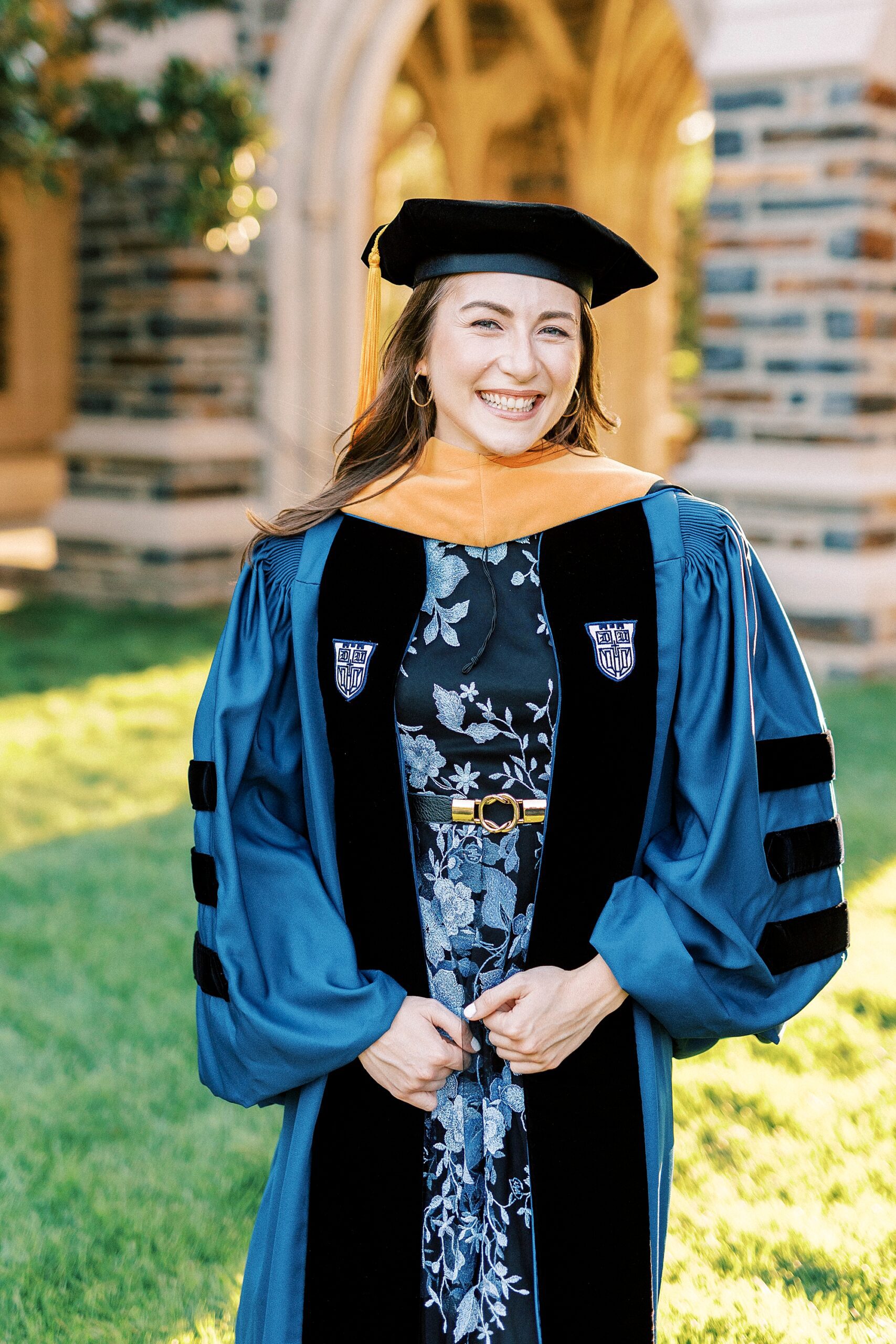 woman smiles in blue and black robe and hat at Duke University