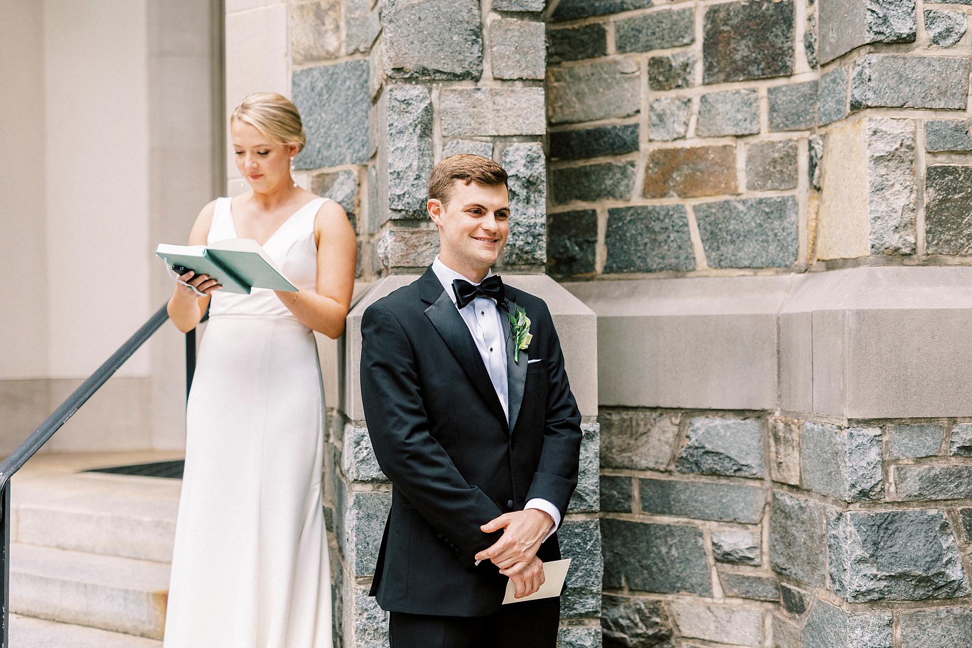 groom stands in front of bride on corner of church during private vows of first touch