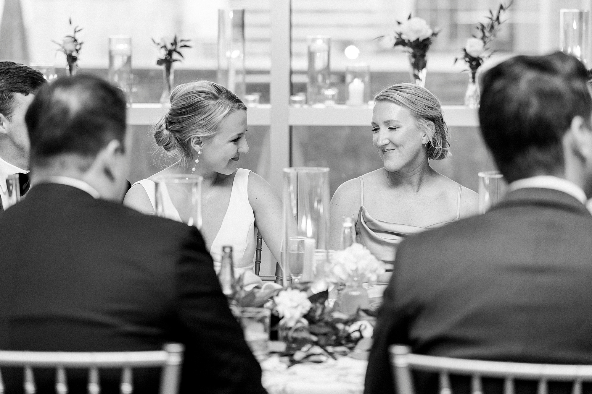 bride smiles at bridesmaid during reception