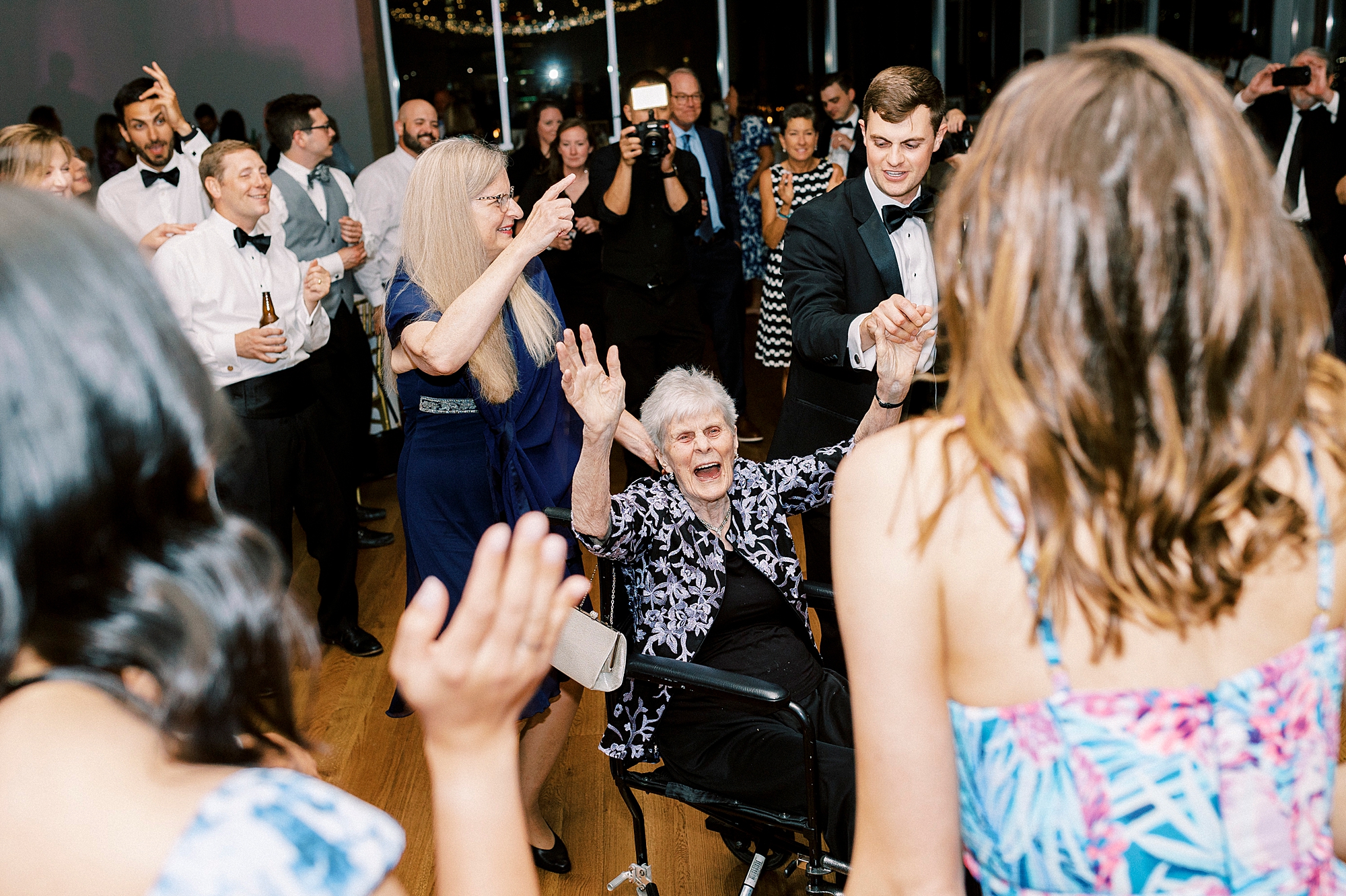 woman sits in chair dancing during reception at the Mint Museum Uptown