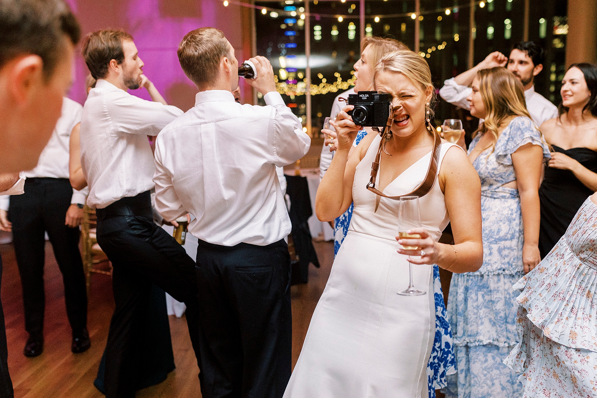 bride takes photo with old film camera during reception