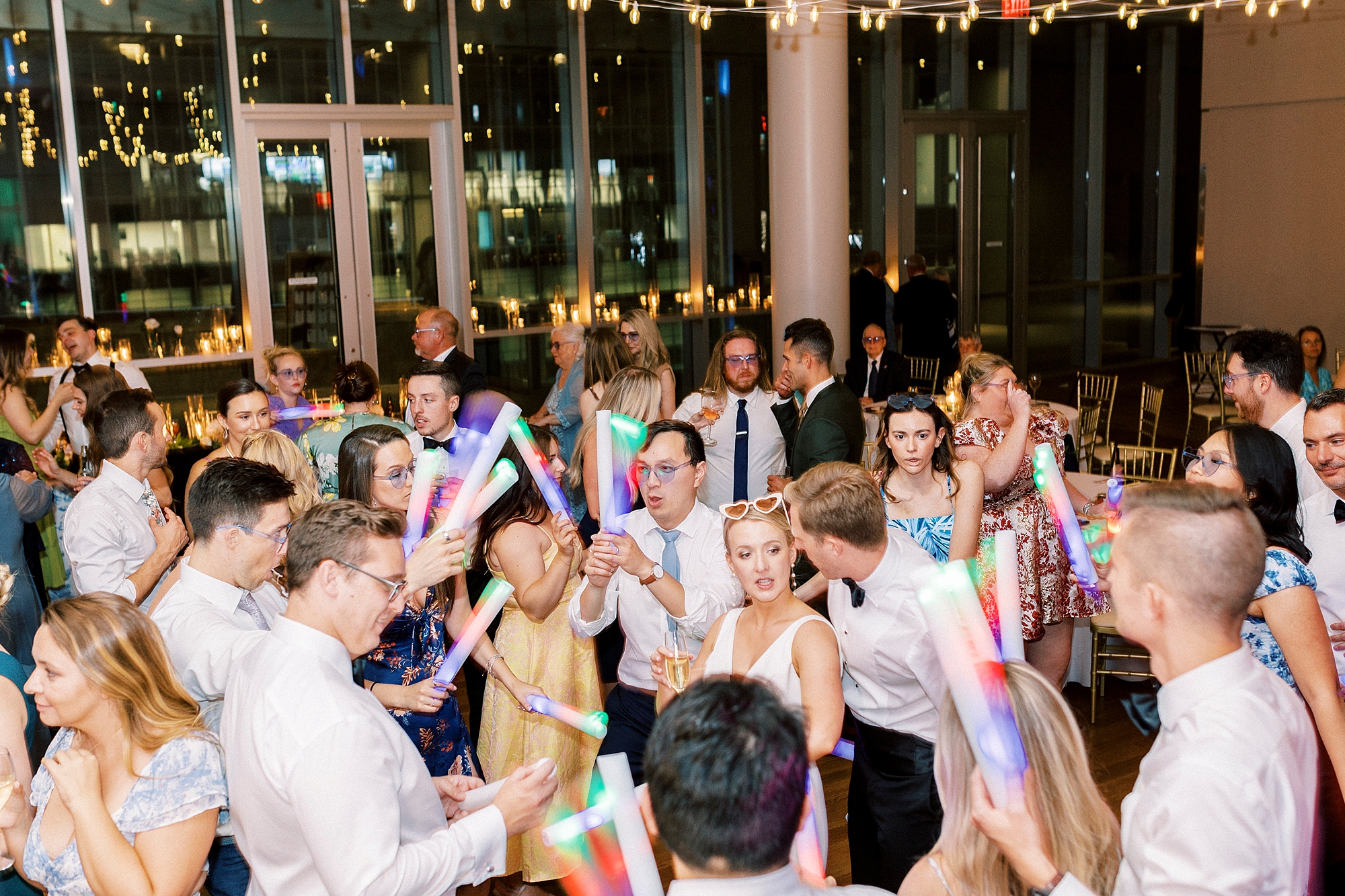 wedding guests dance with glow sticks at the Mint Museum Uptown