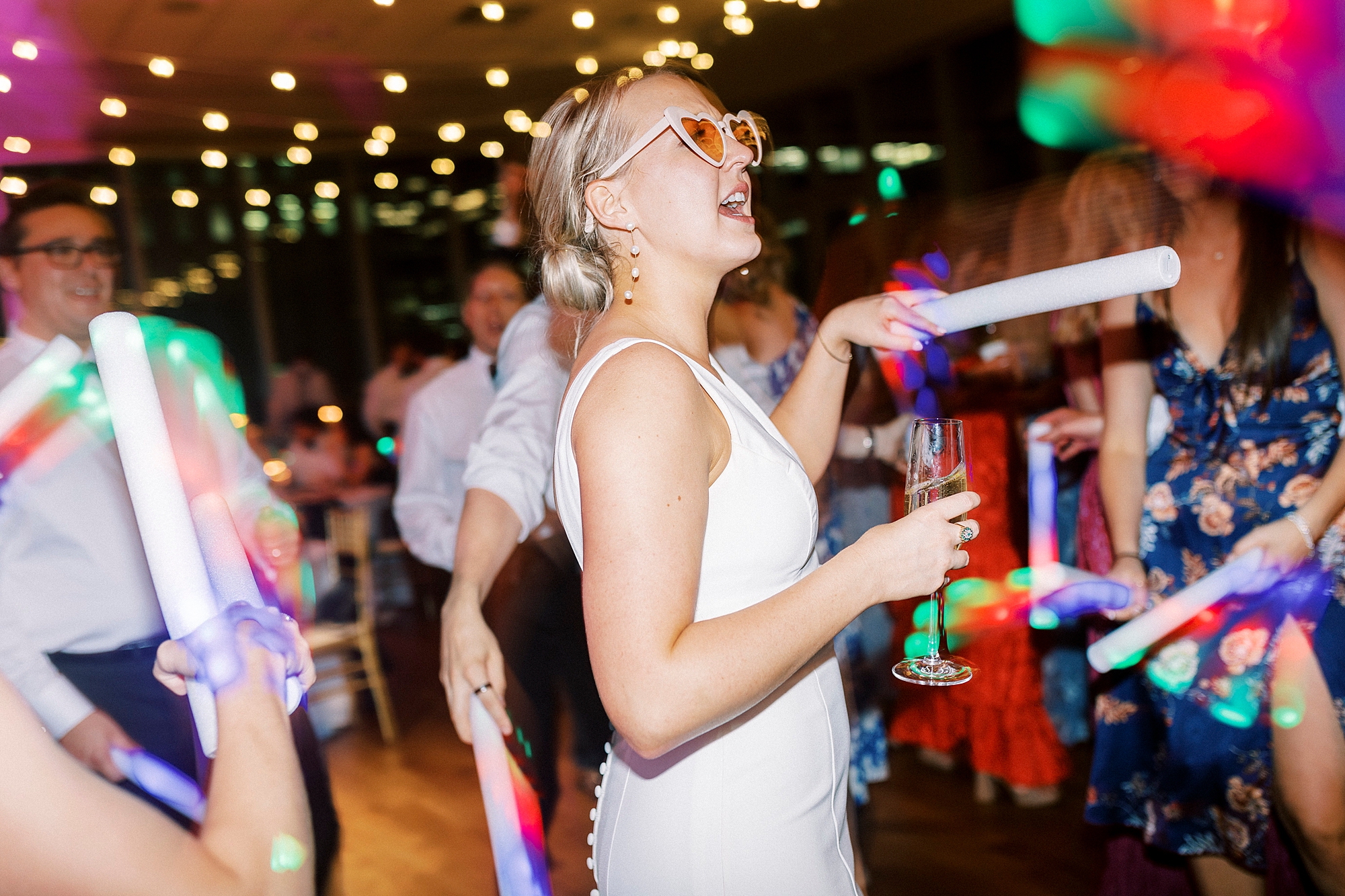 bride sings holding glowstick at the Mint Museum Uptown