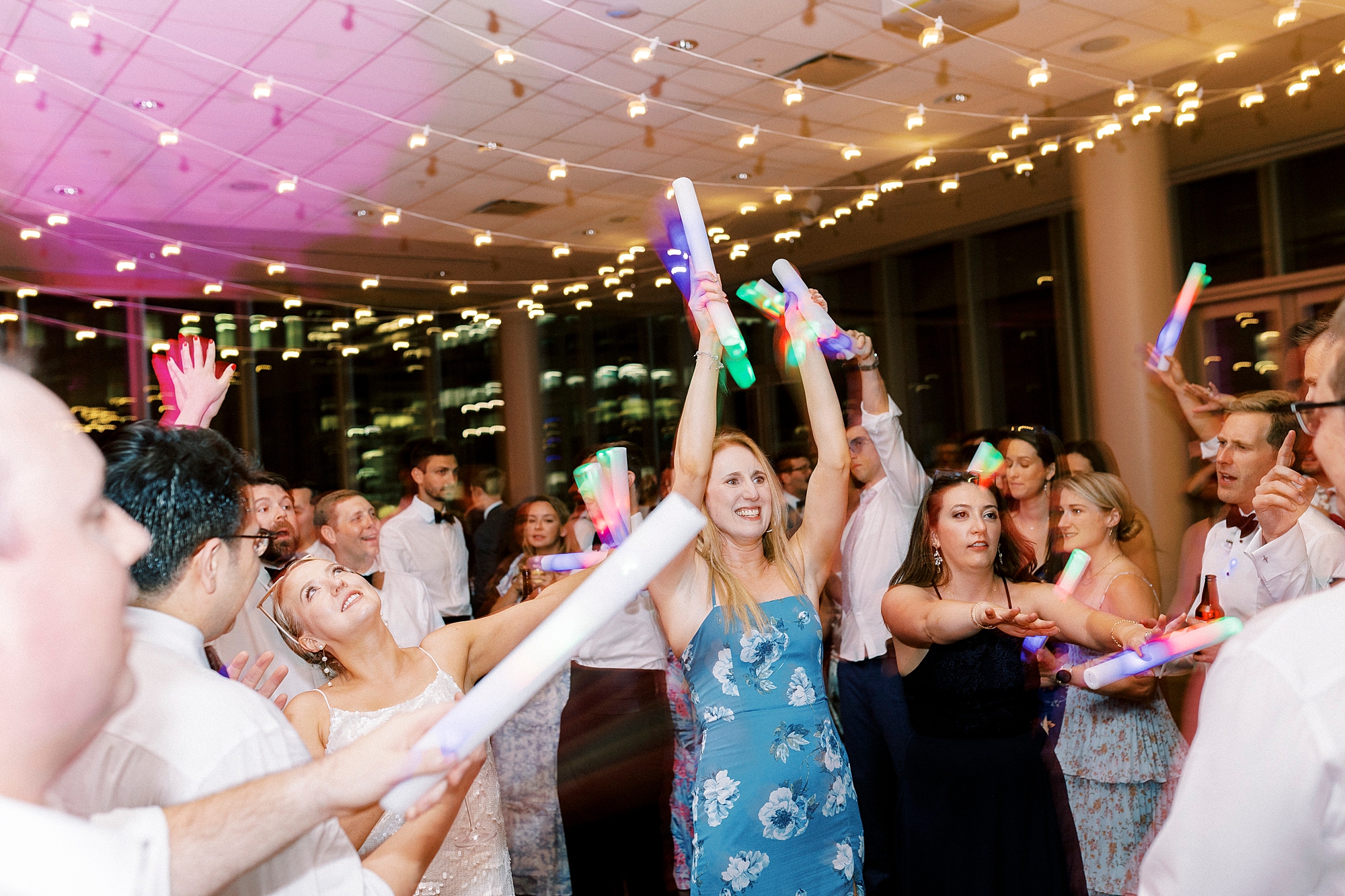 wedding guests dance with glow sticks at the Mint Museum Uptown