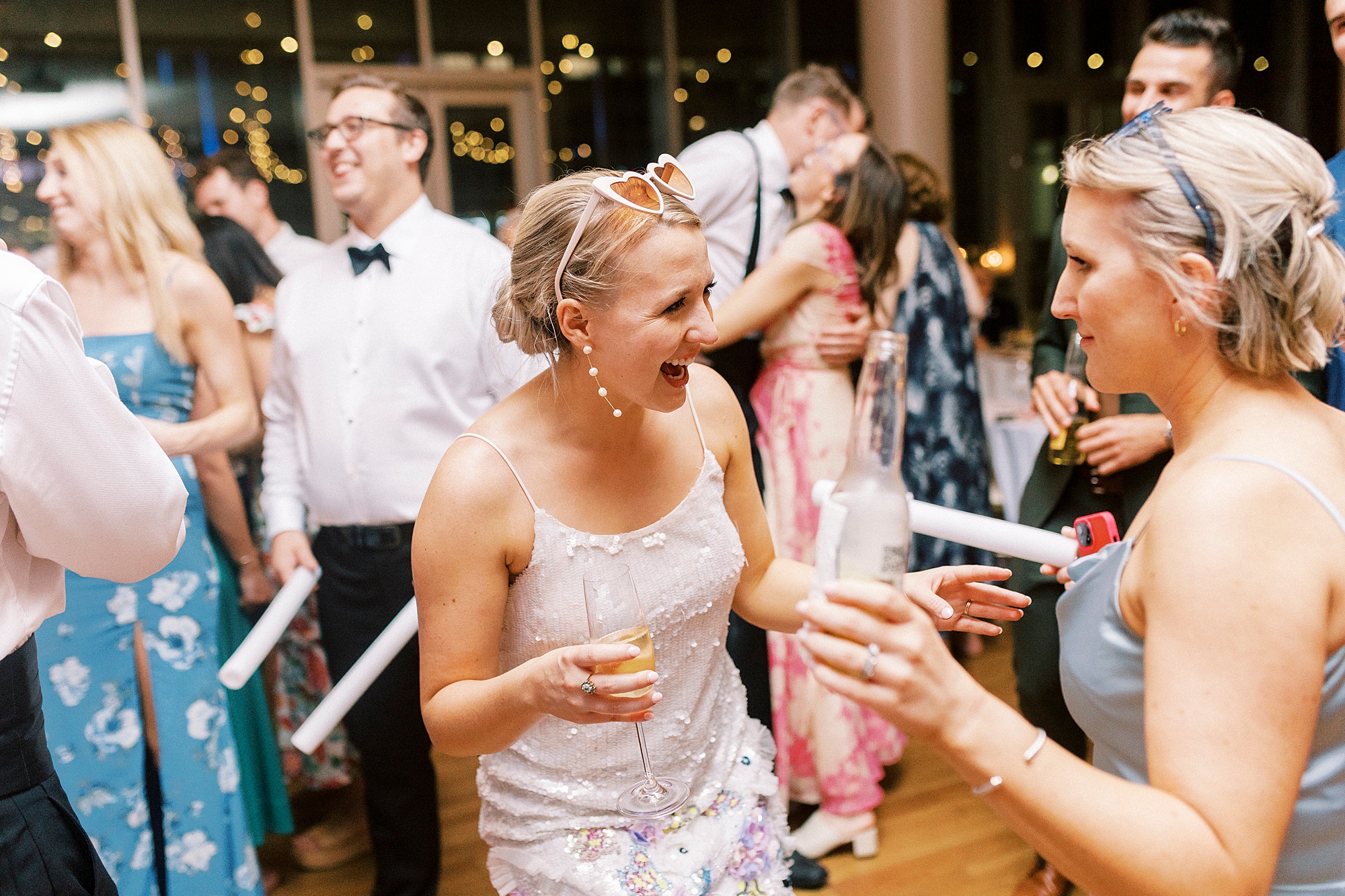 bride dances in short party dress with guests at the Mint Museum Uptown