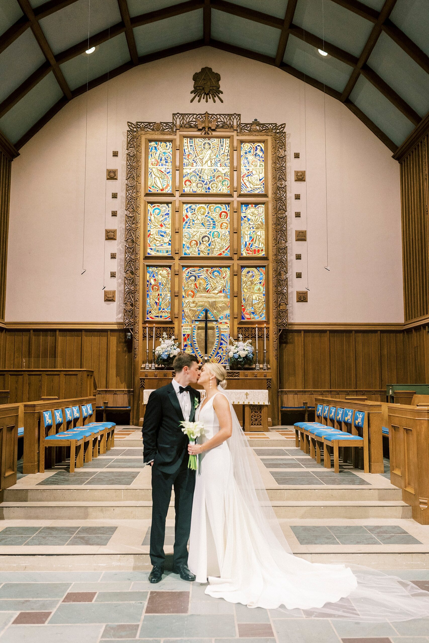 bride and groom kiss by alter of Meyers Presbyterian church