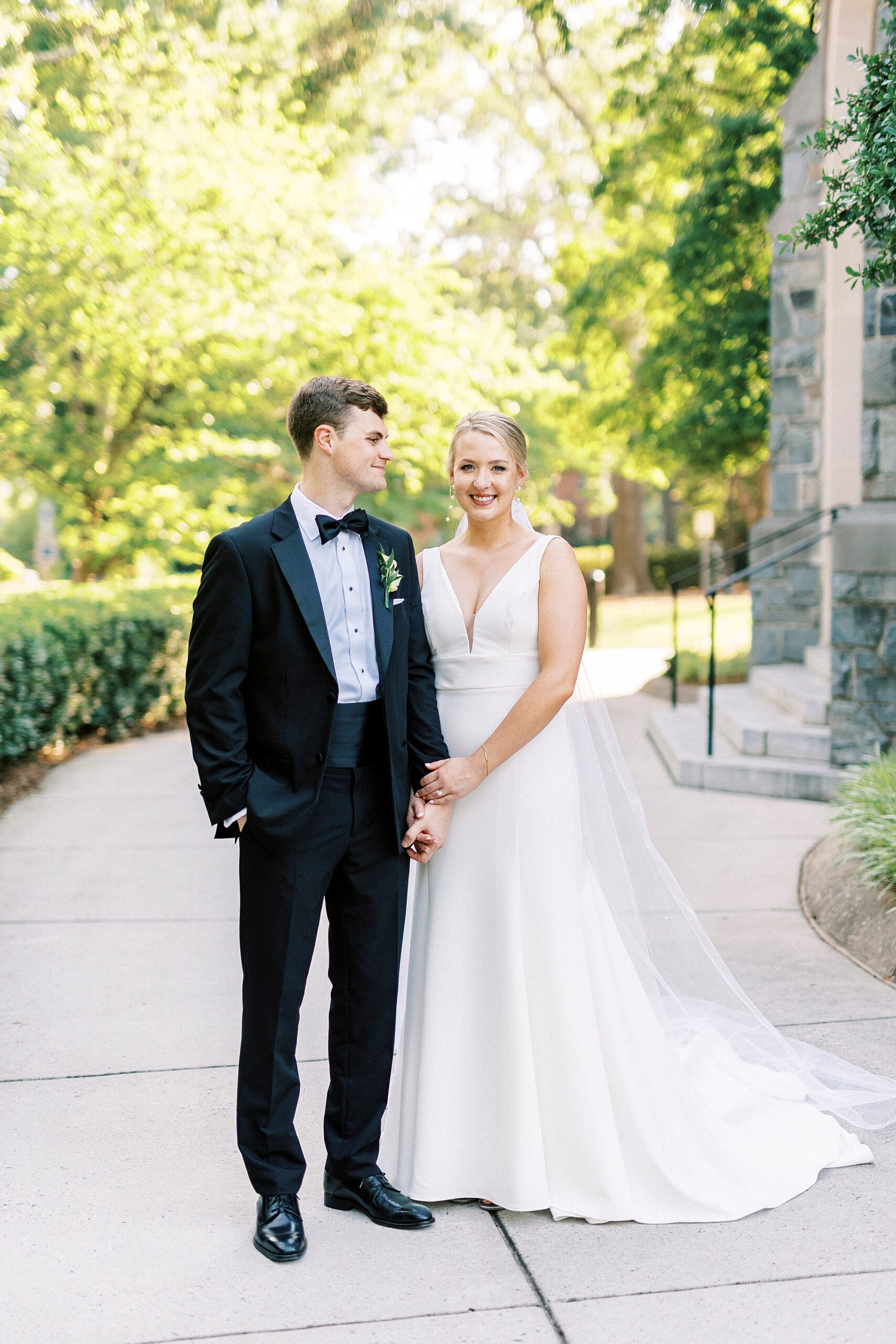 bride holds groom's hand outside Charlotte NC church