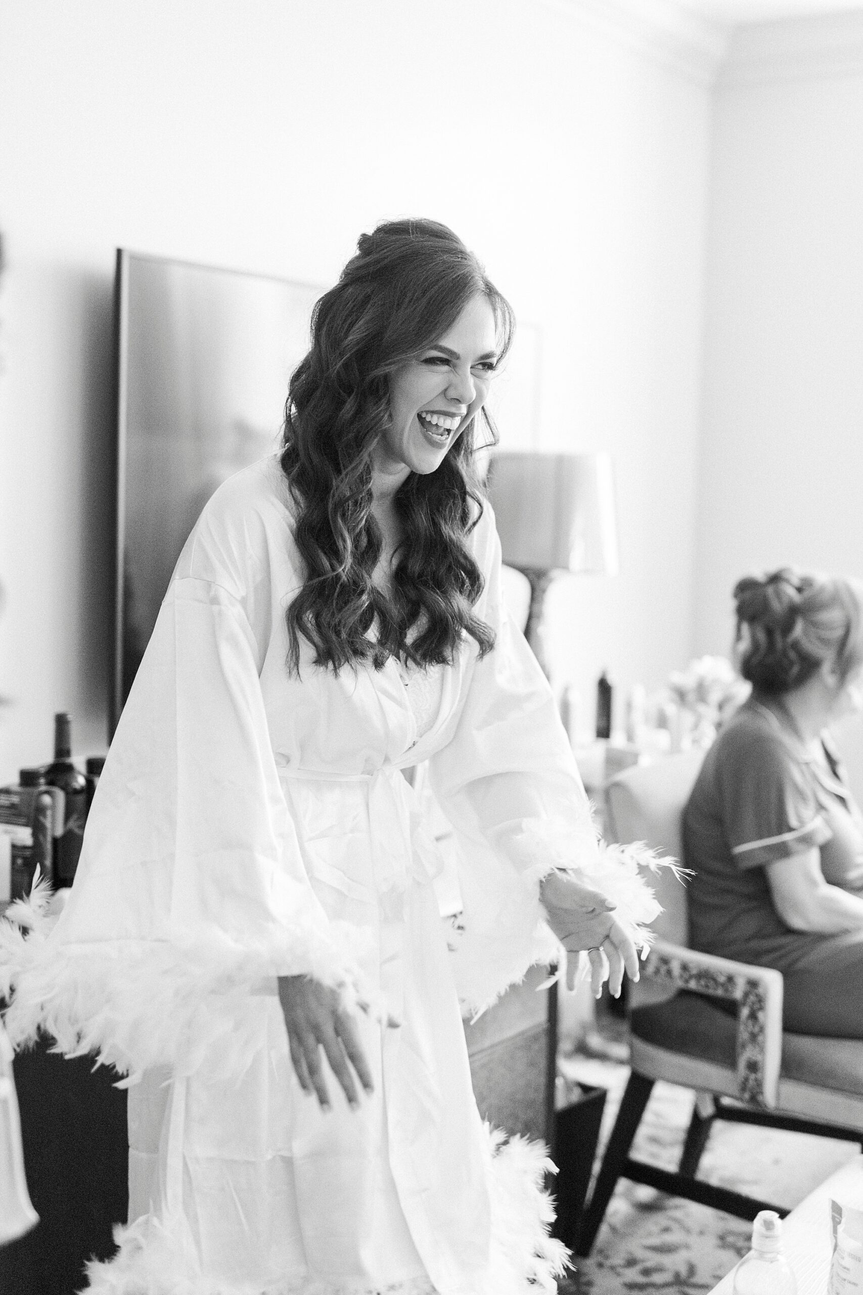 bride grins while getting ready with bridesmaids in Charlotte hotel