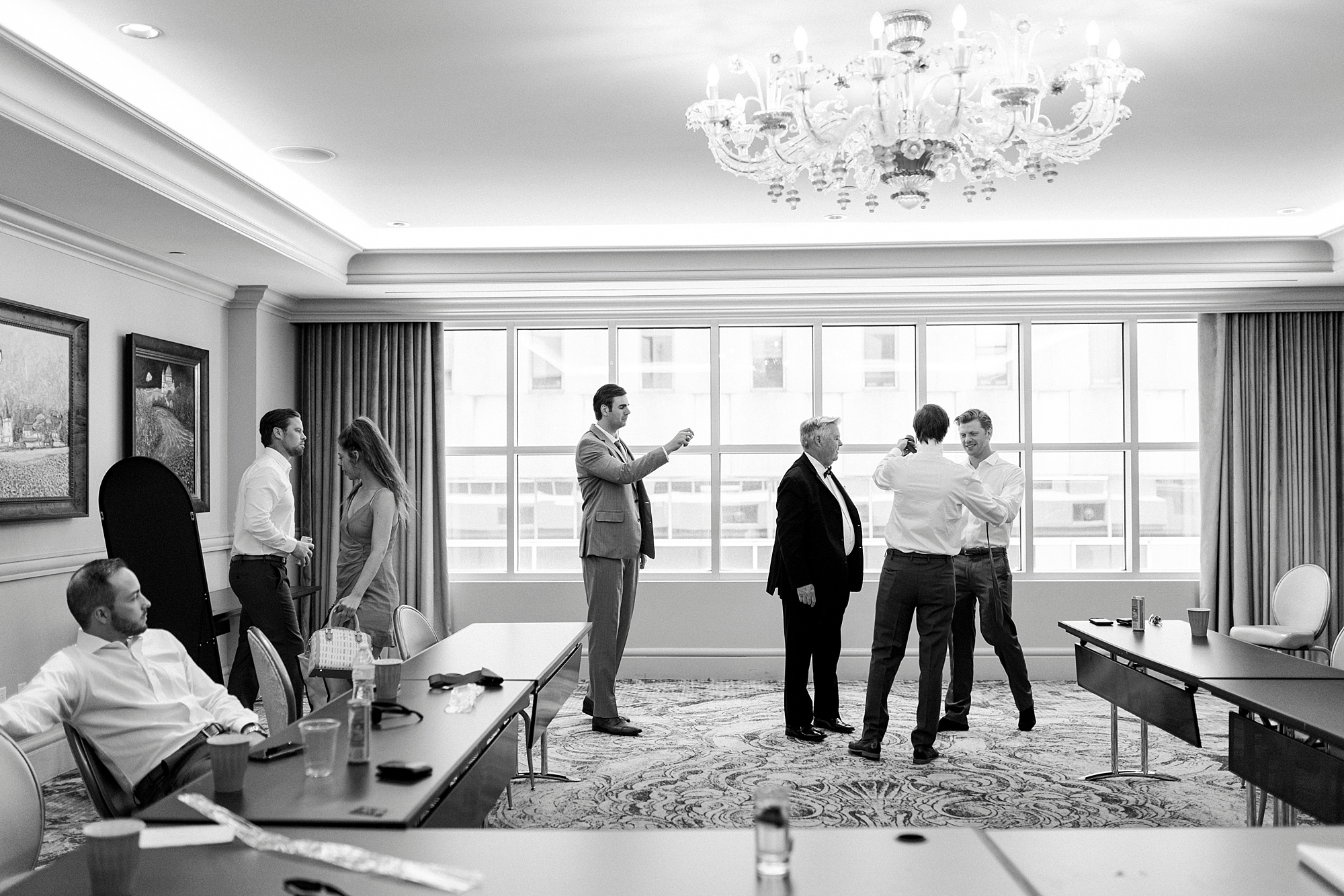 groomsmen mingle around ballroom preparing for wedding