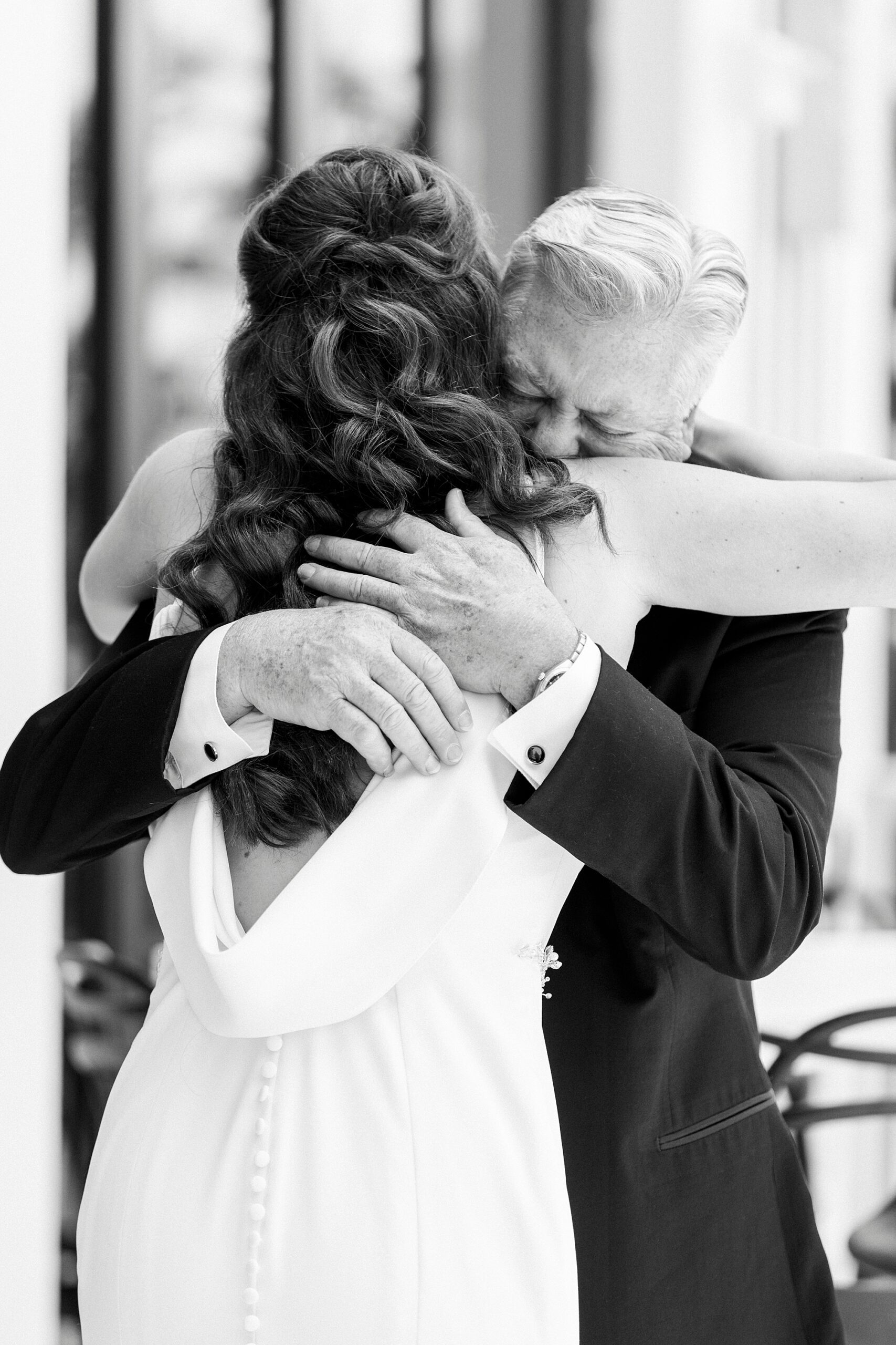 dad hugs bride tight during first look on Charlotte hotel balcony