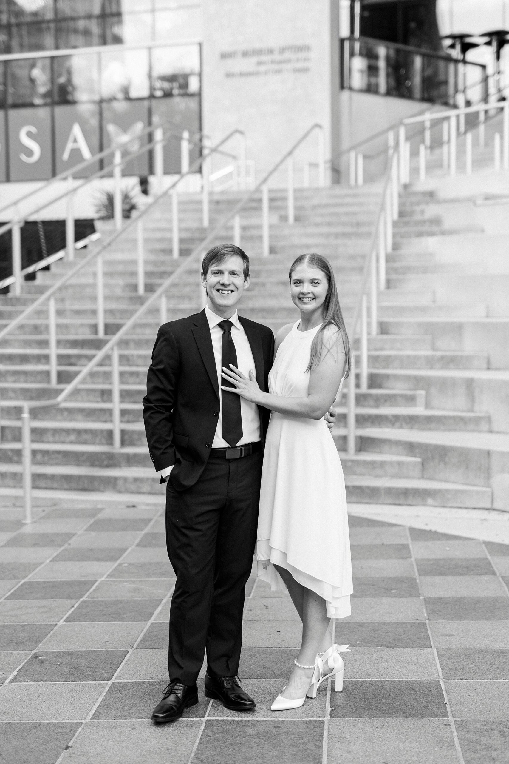 engaged couple stands on patio in front of the Mint Museum in Charlotte NC