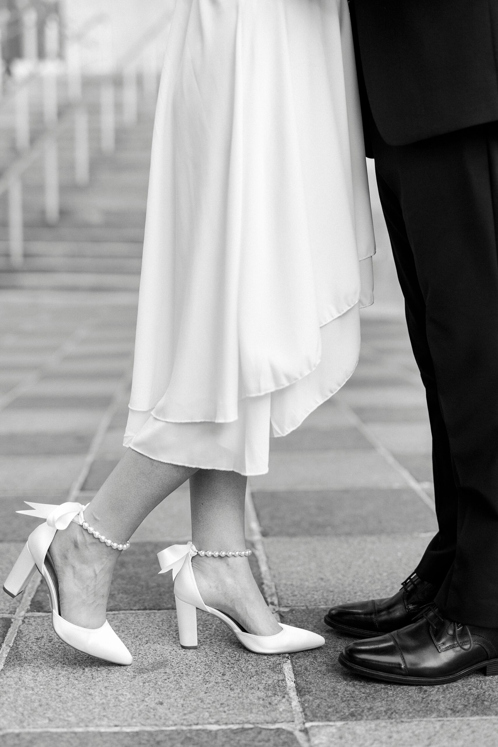woman lifts back foot slightly hugging fiancee outside the Mint Museum in Charlotte NC