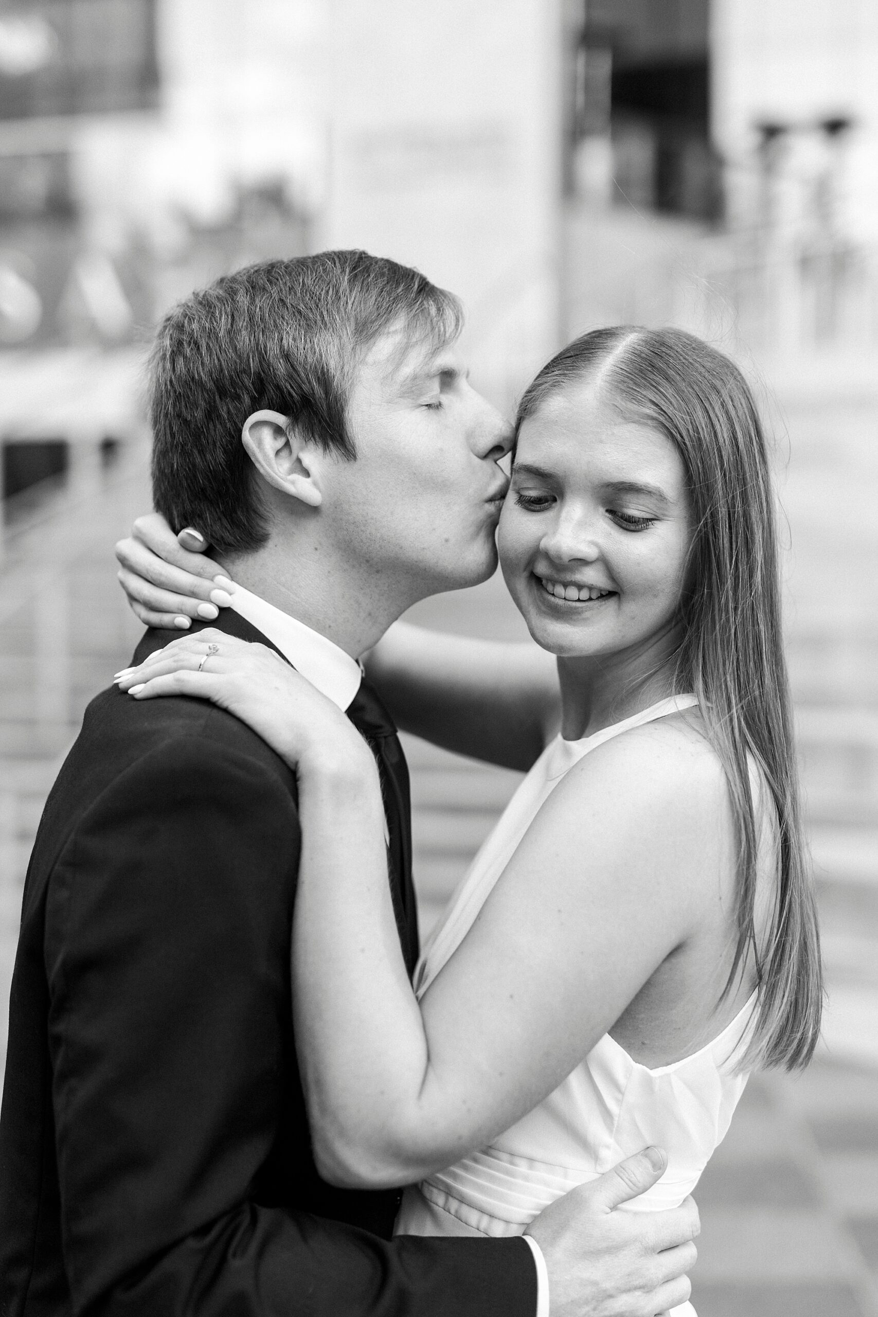 man kisses woman's forehead during Charlotte NC engagement session 