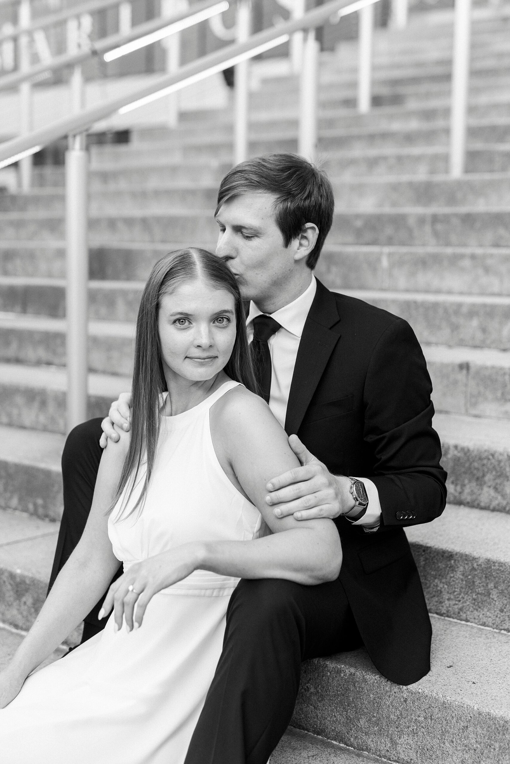 man kisses woman's forehead while she sits between his knees