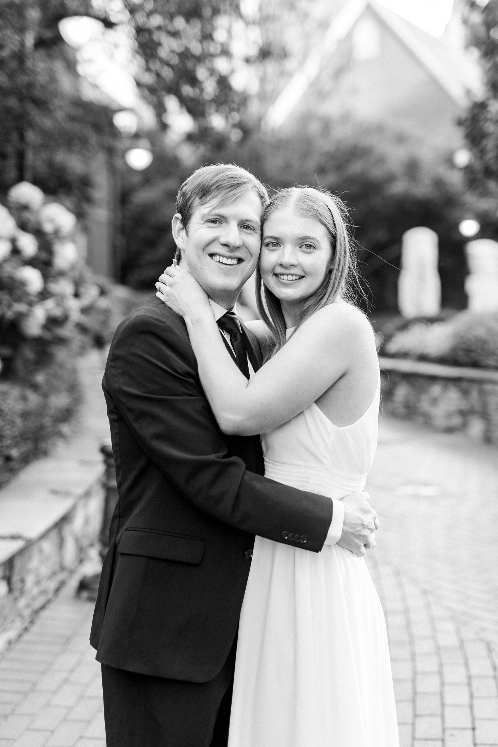 man and woman hug holding heads together during Uptown Charlotte engagement session