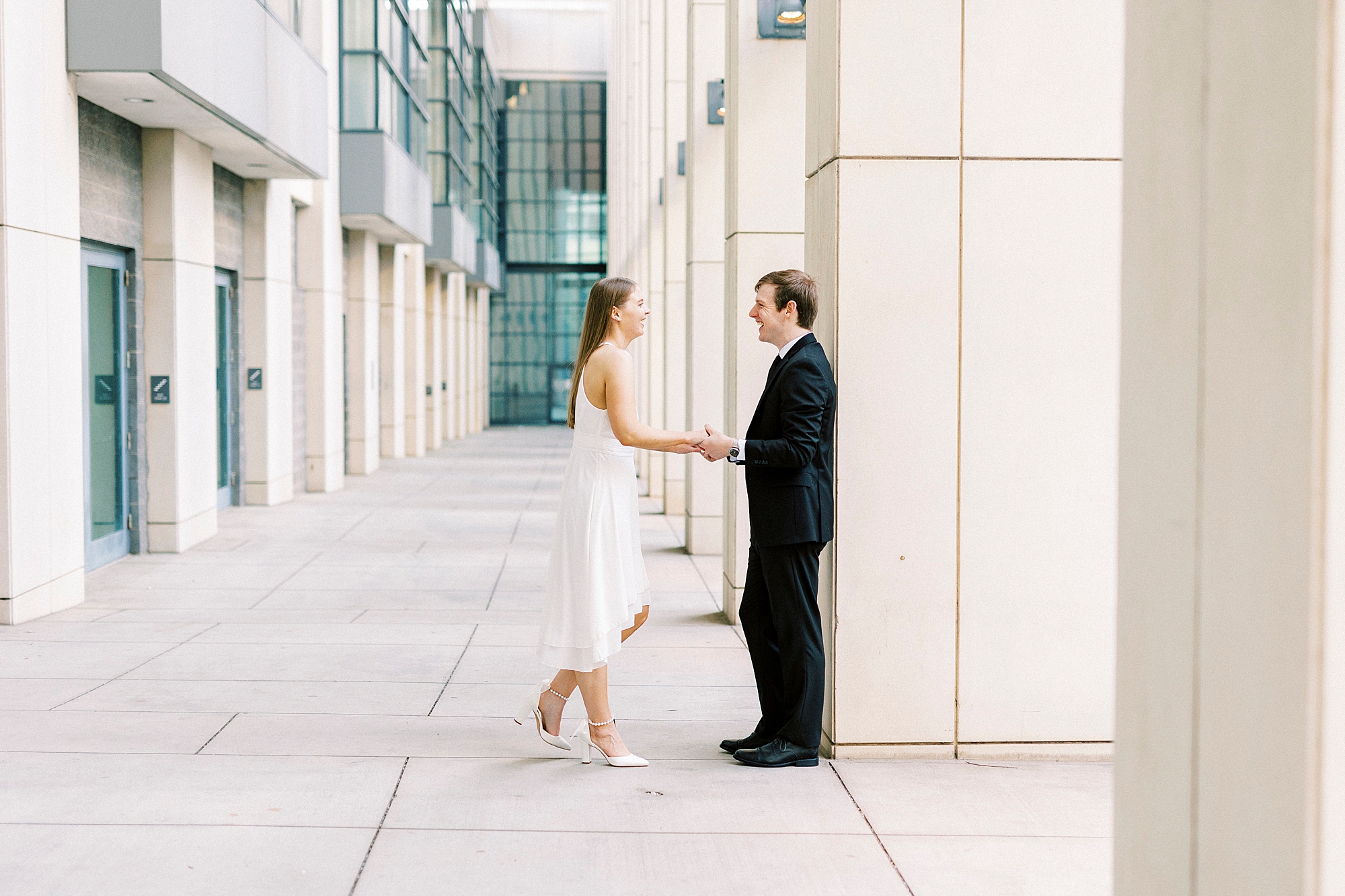 engaged couple holds hands walking at Charlotte Convention Center