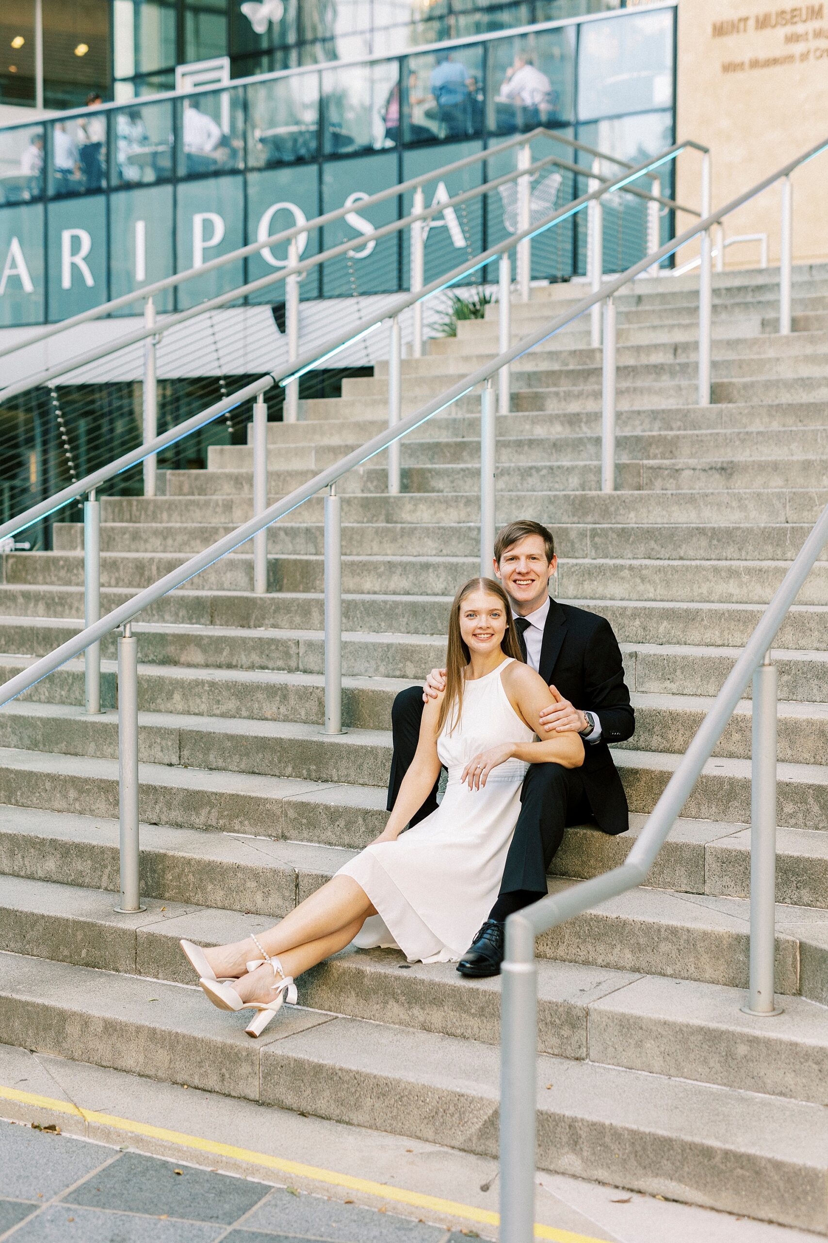 man and woman sit on steps outside the Mint Museum in Charlotte NC
