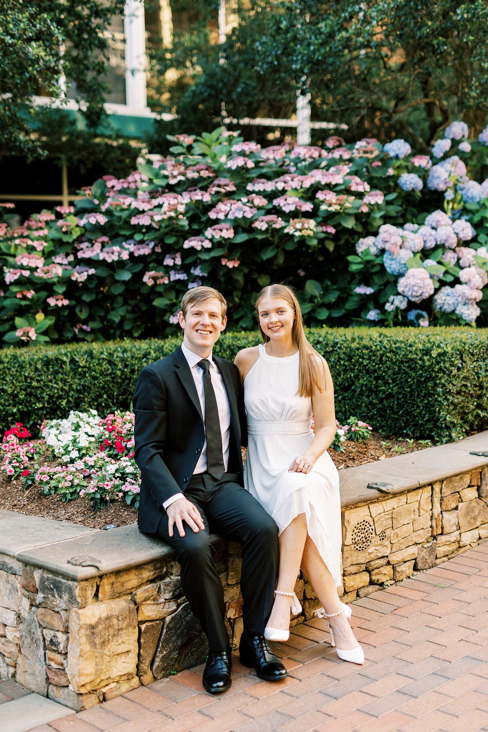 couple sits on stone bench in Uptown Charlotte