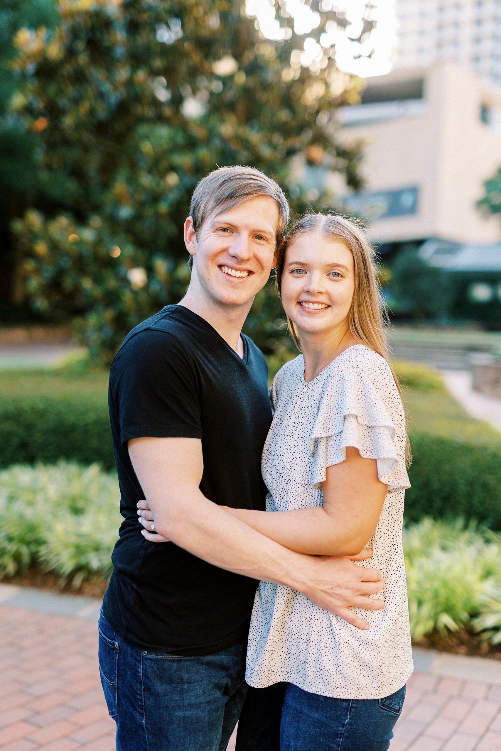 man and woman hug leaning heads together in Charlotte NC park